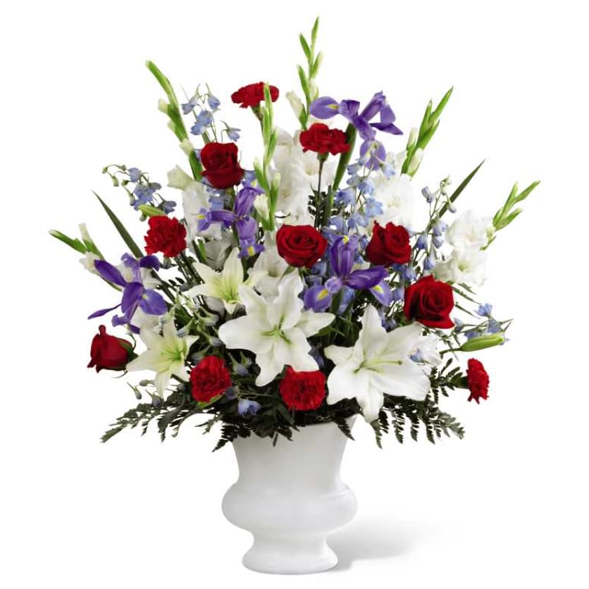 Red roses and white lilies with purple flowers in a white vase