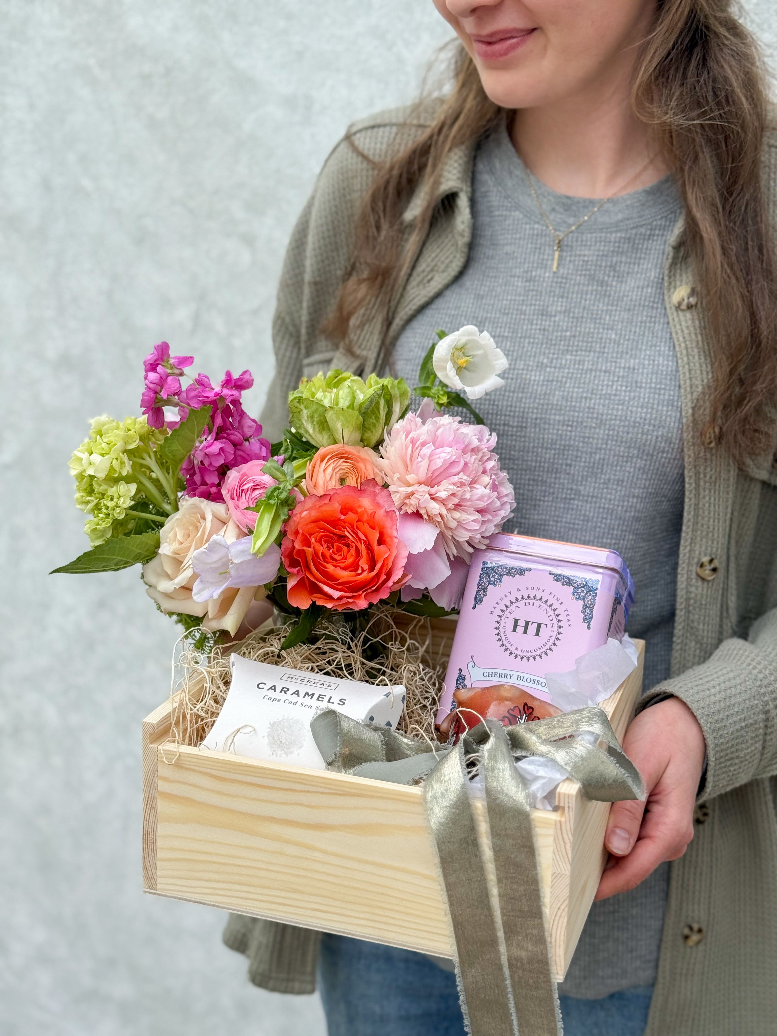 Gift Box for Mom - A beautiful way to show your love, this thoughtfully curated gift box features a fresh seasonal floral arrangement paired with soothing cherry blossom tea, indulgent sea salt caramels, and a warm pomegranate-scented candle.  All are nestled inside a charming wooden keepsake box she can treasure long after the treats are gone perfect for Mother’s Day or any moment she deserves something special.