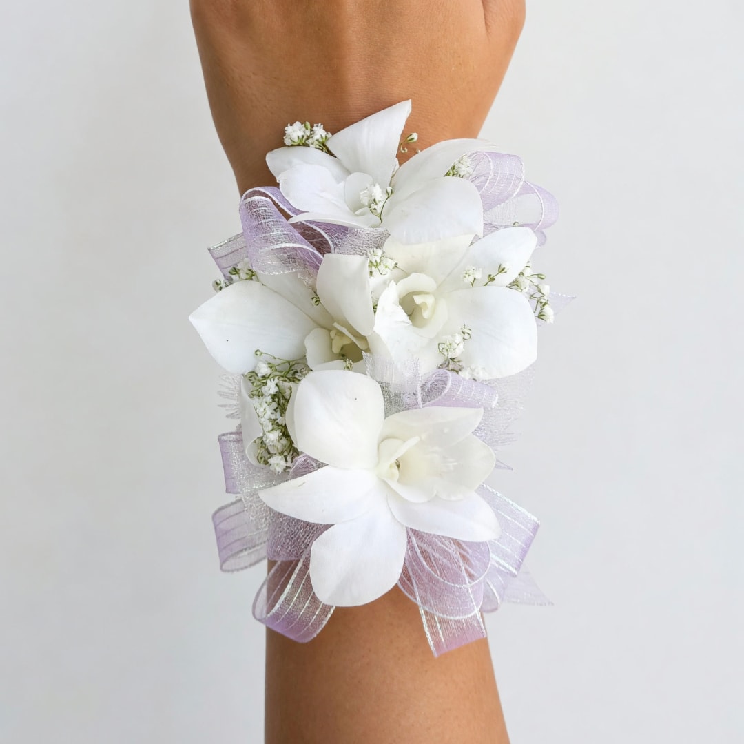 White floral wrist corsage with lavender ribbon on an arm