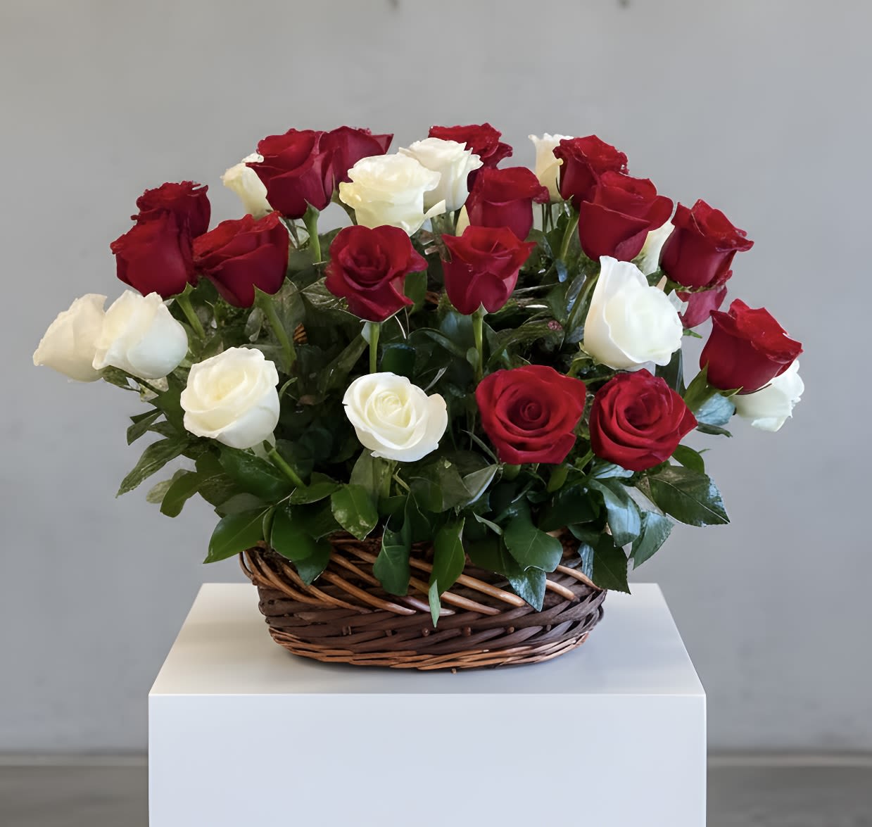 Basket of red and white roses on a white pedestal