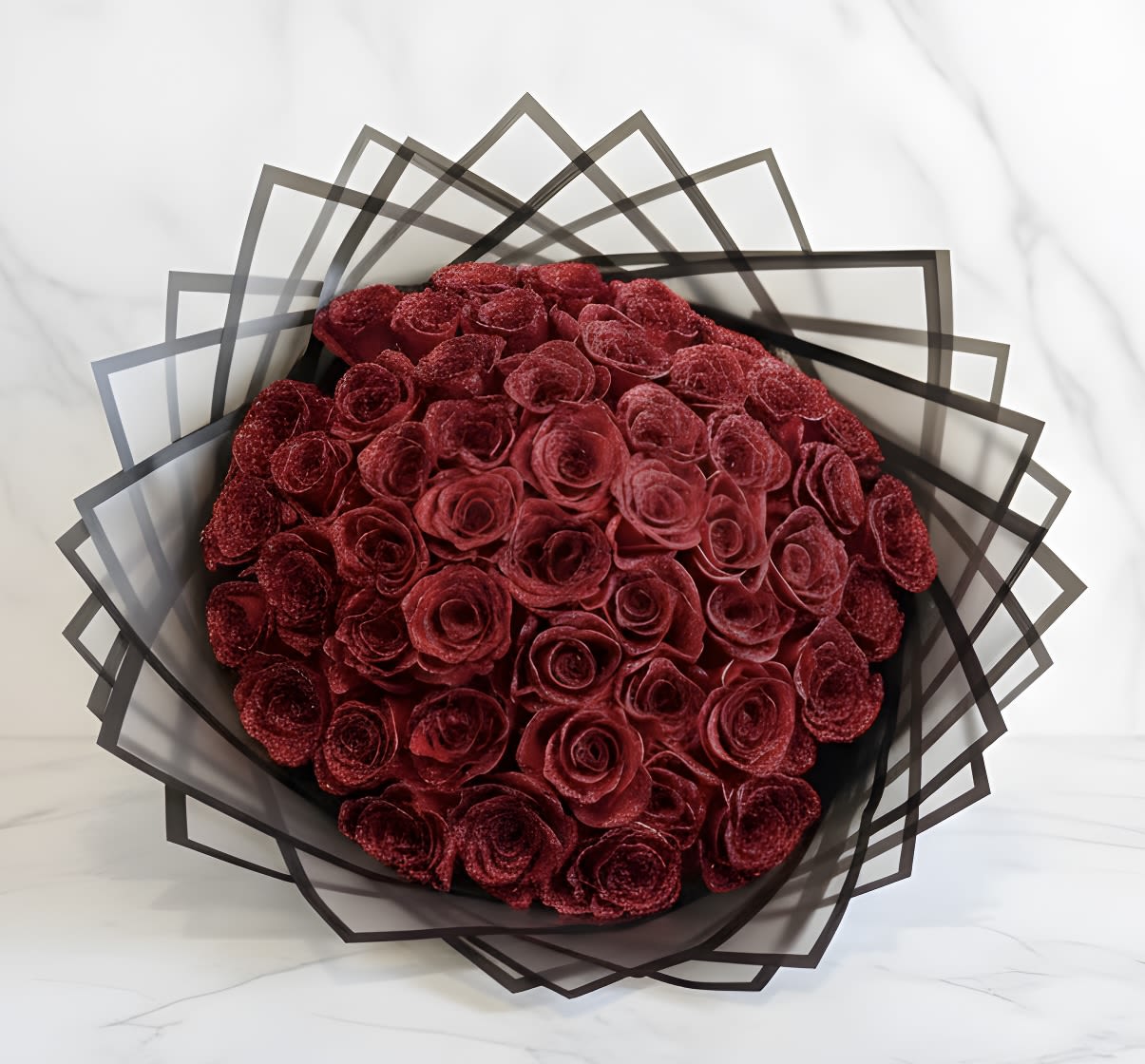 Bouquet of deep red roses wrapped in geometric black paper