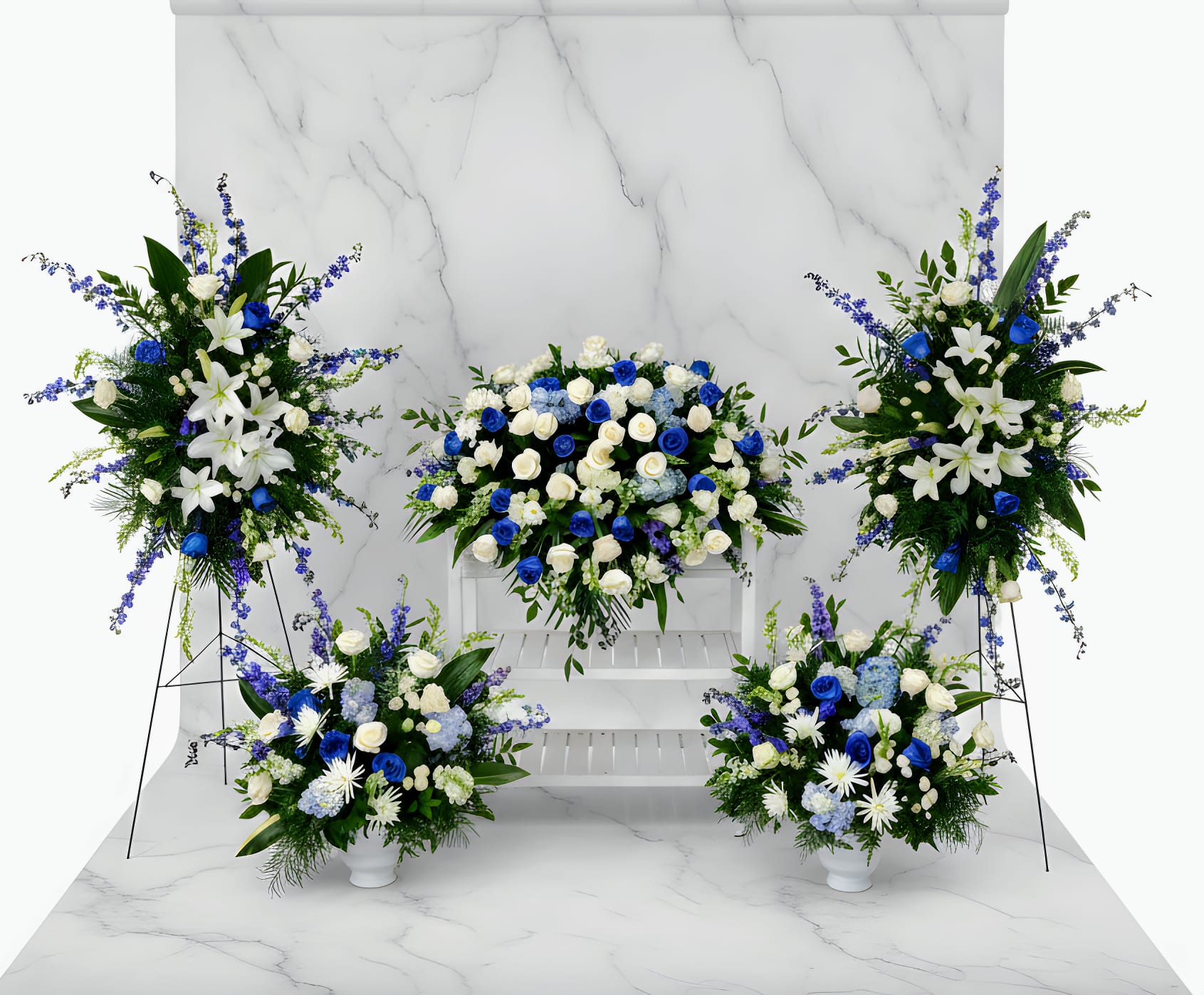 Blue and white floral funeral display with standing sprays and vase arrangements