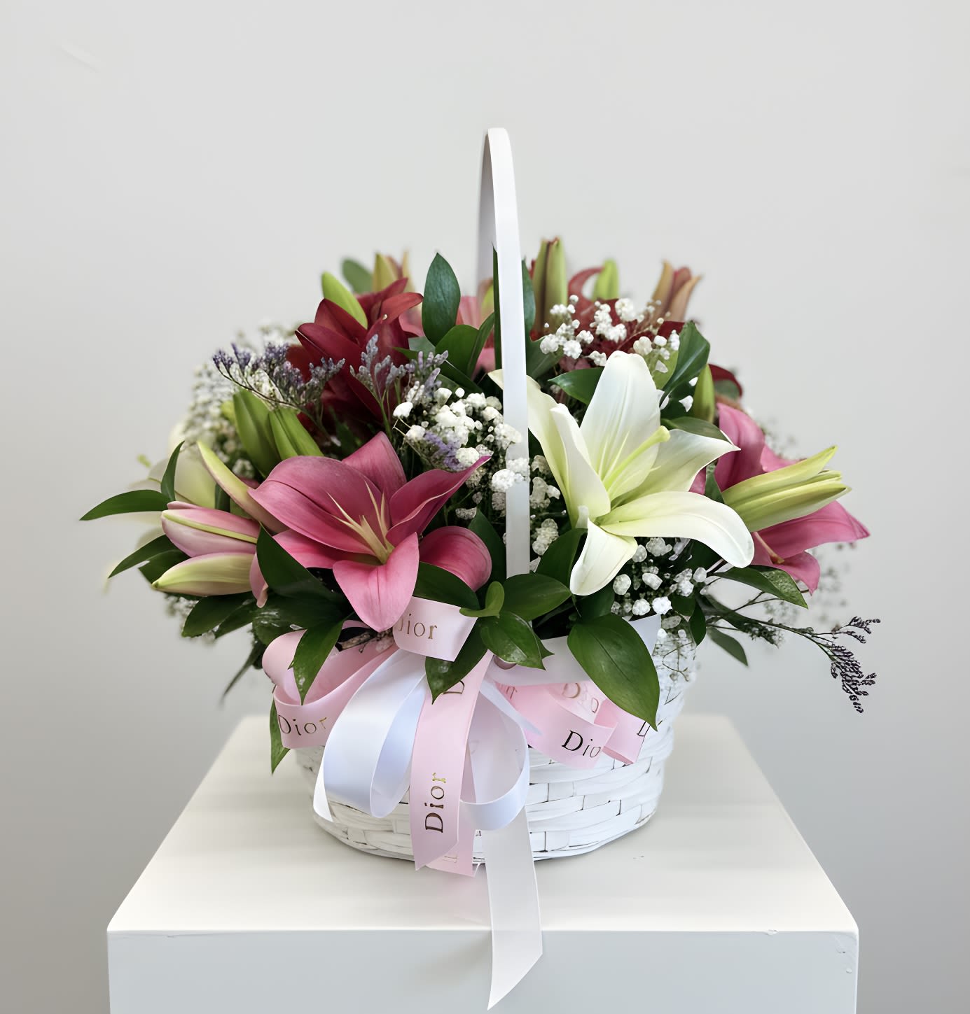 Colorful Lily Basket - A charming wooden basket filled with a radiant mix of colorful lilies, this arrangement brings together elegance and natural beauty. Each bloom is carefully arranged to create a balanced and eye-catching display. Accented with fresh greenery, the lilies add both texture and a light, refreshing fragrance to the design.  Perfect for birthdays, celebrations, or simply brightening someone’s day, this basket offers a warm, rustic touch combined with the timeless sophistication of lilies. Its wooden base makes it easy to display on tables, desks, or entryways, making it both a thoughtful and stylish gift.