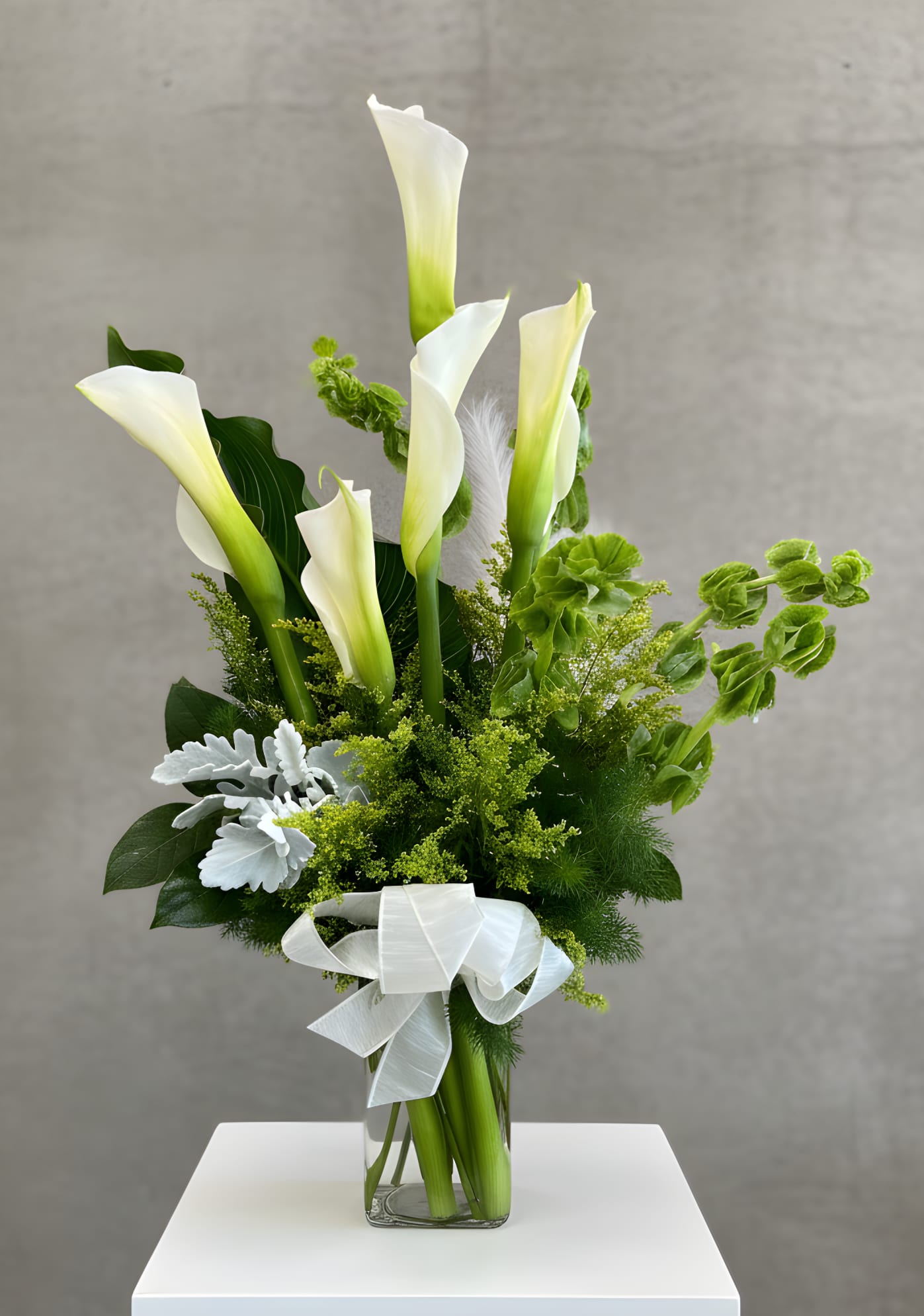 Calla Lily By Zayda - A stunning arrangement of fresh Calla Lilies, known for their sleek, trumpet-like form and timeless beauty. Designed to evoke elegance and grace, this piece is perfect for weddings, anniversaries, or simply adding a touch of sophistication to your home or event. Standard 6 Calla Lilies Deluxe 12 Calla Lilies Premium 24 Calla Lilies
