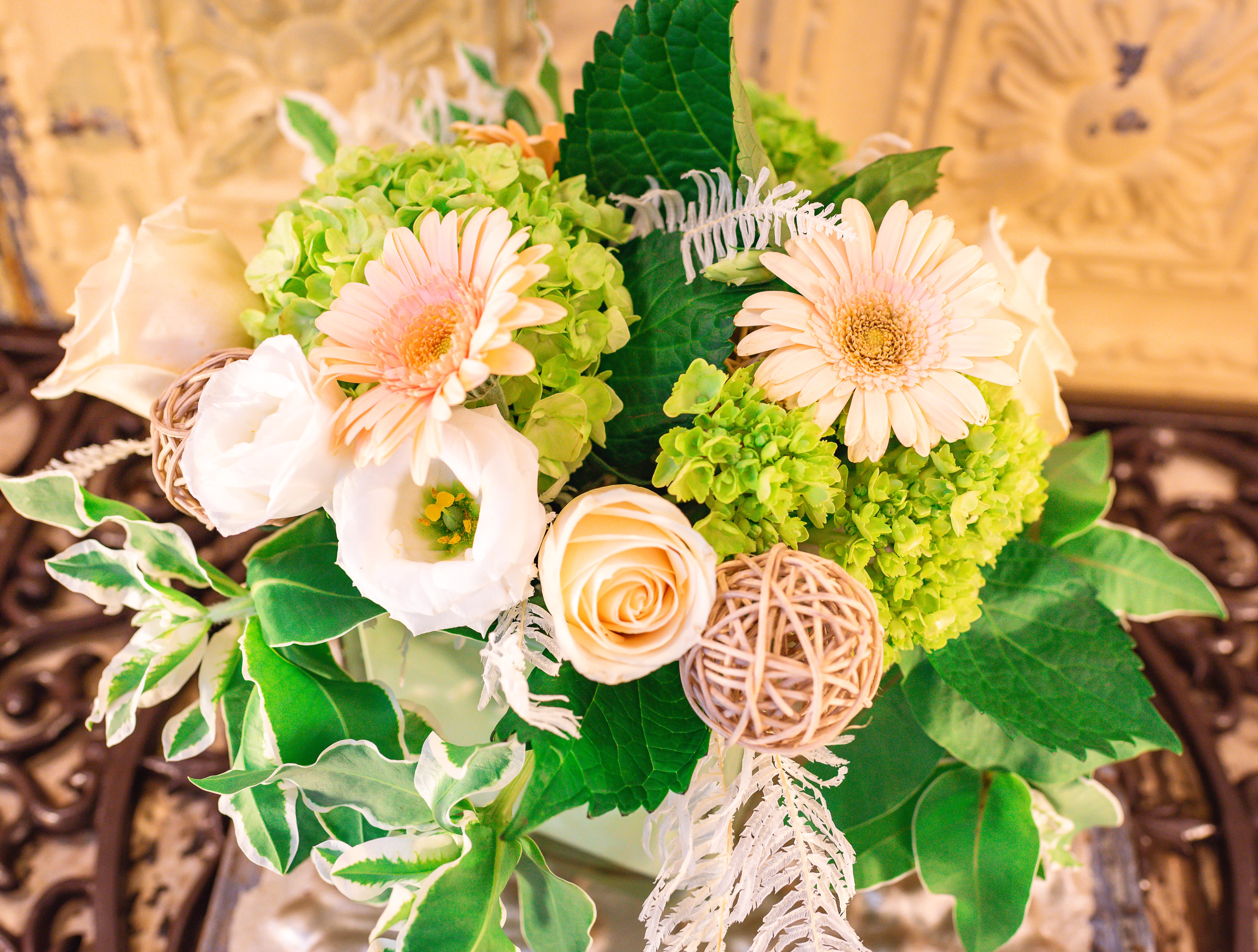 Bouquet of pale peach flowers and green hydrangeas with decorative accents