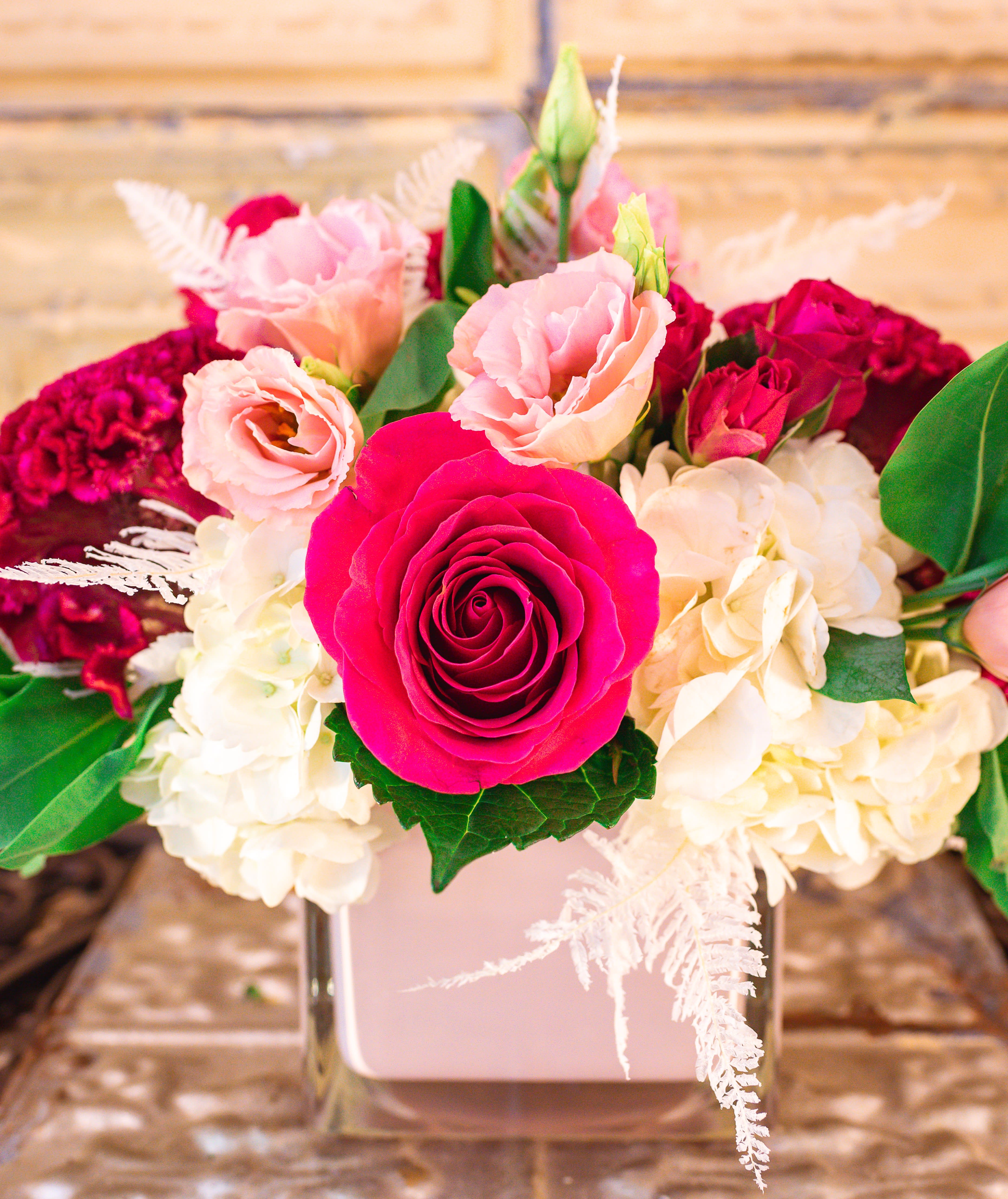 Pink and white floral arrangement in a square vase
