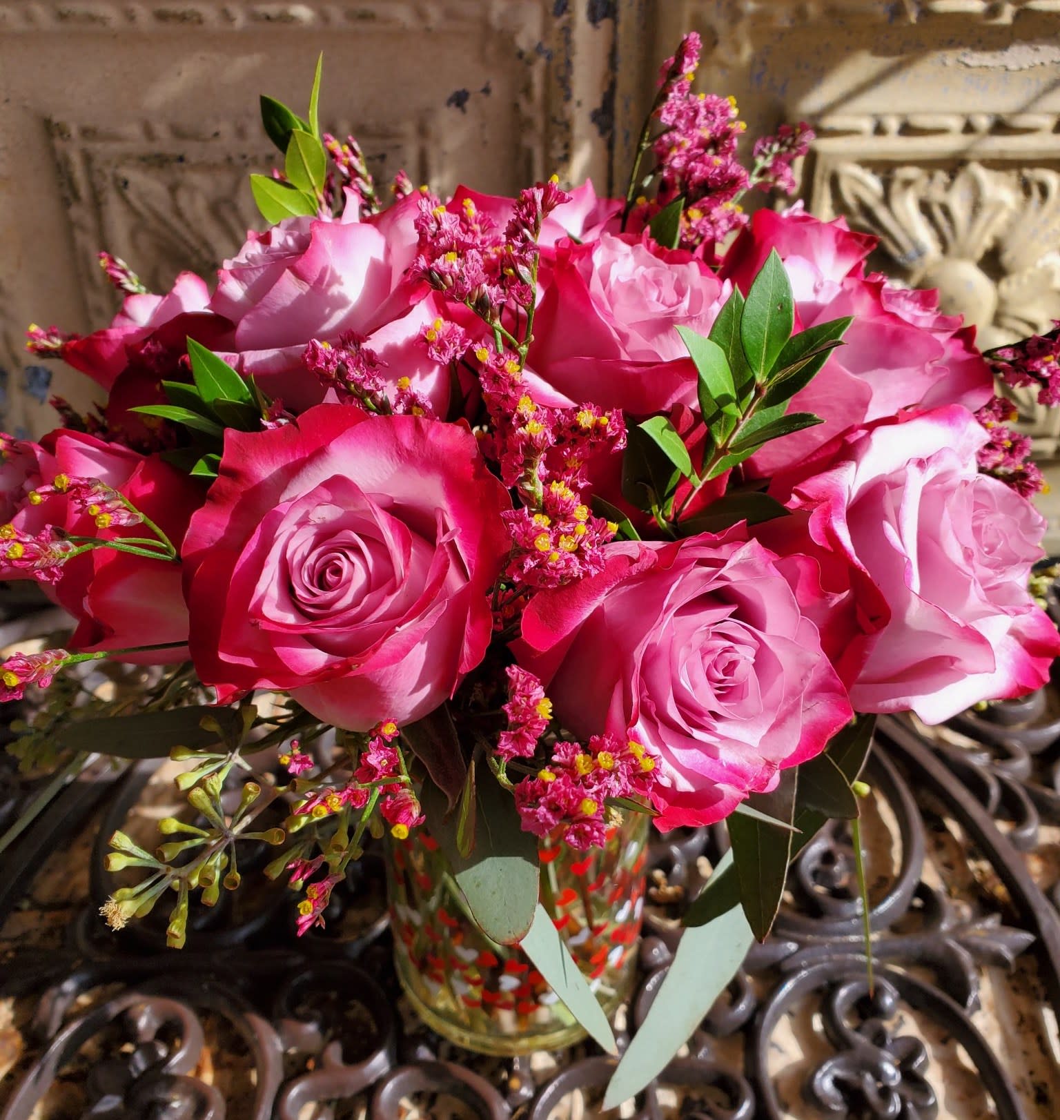 Pink and white roses arranged in a glass vase
