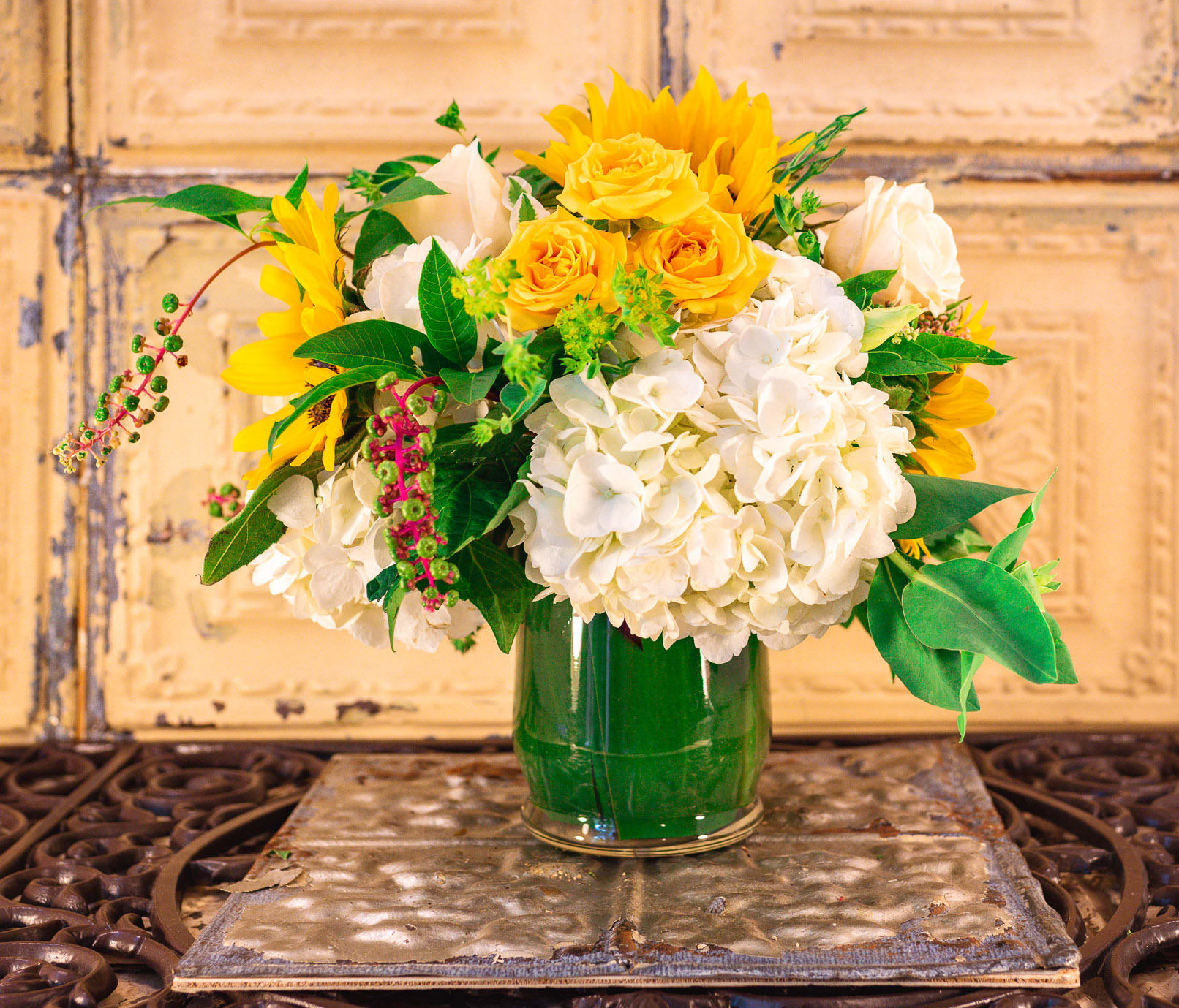 Yellow sunflowers and white hydrangeas in a glass vase