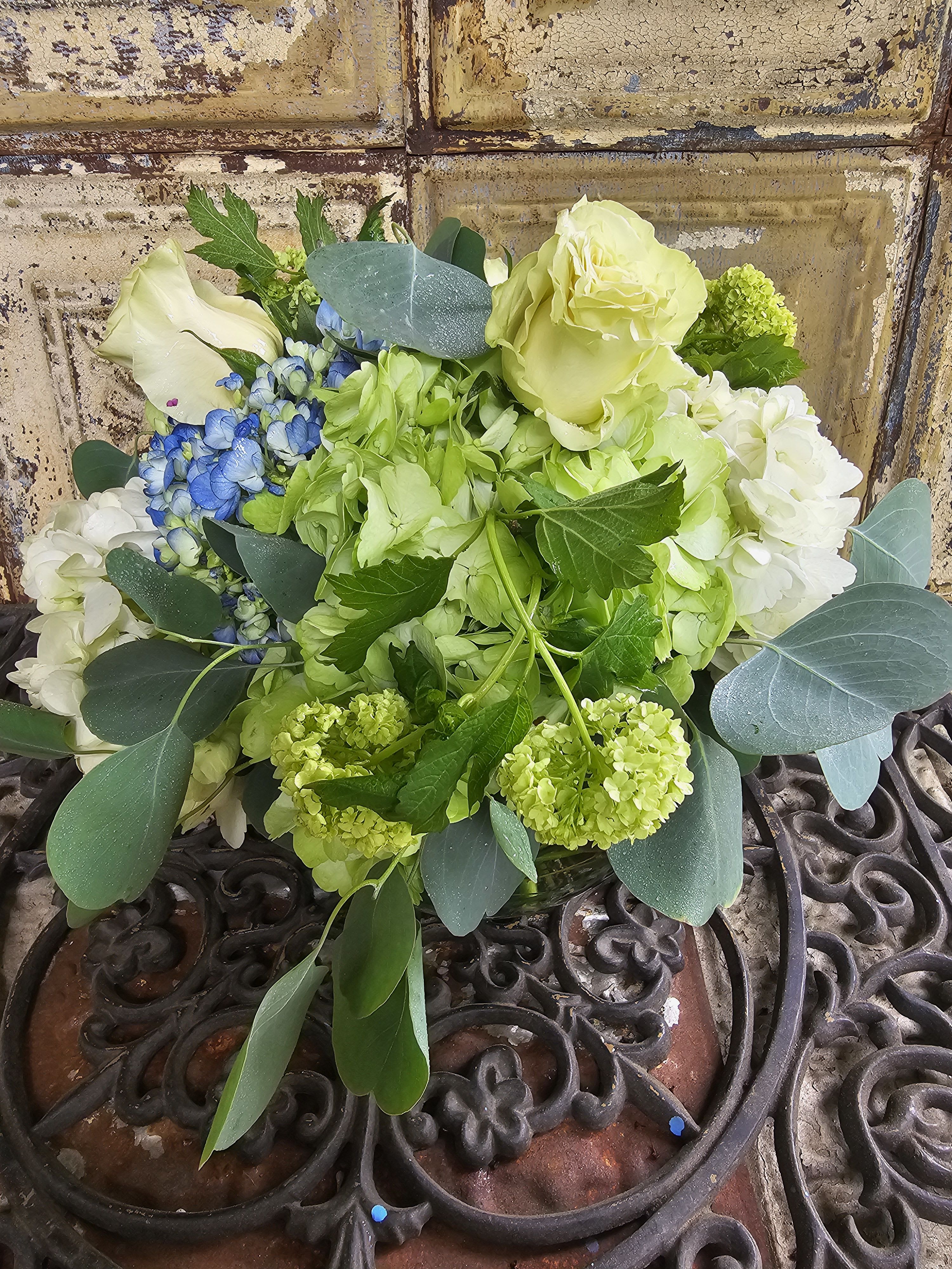 Bouquet of pale green and white flowers with blue accents
