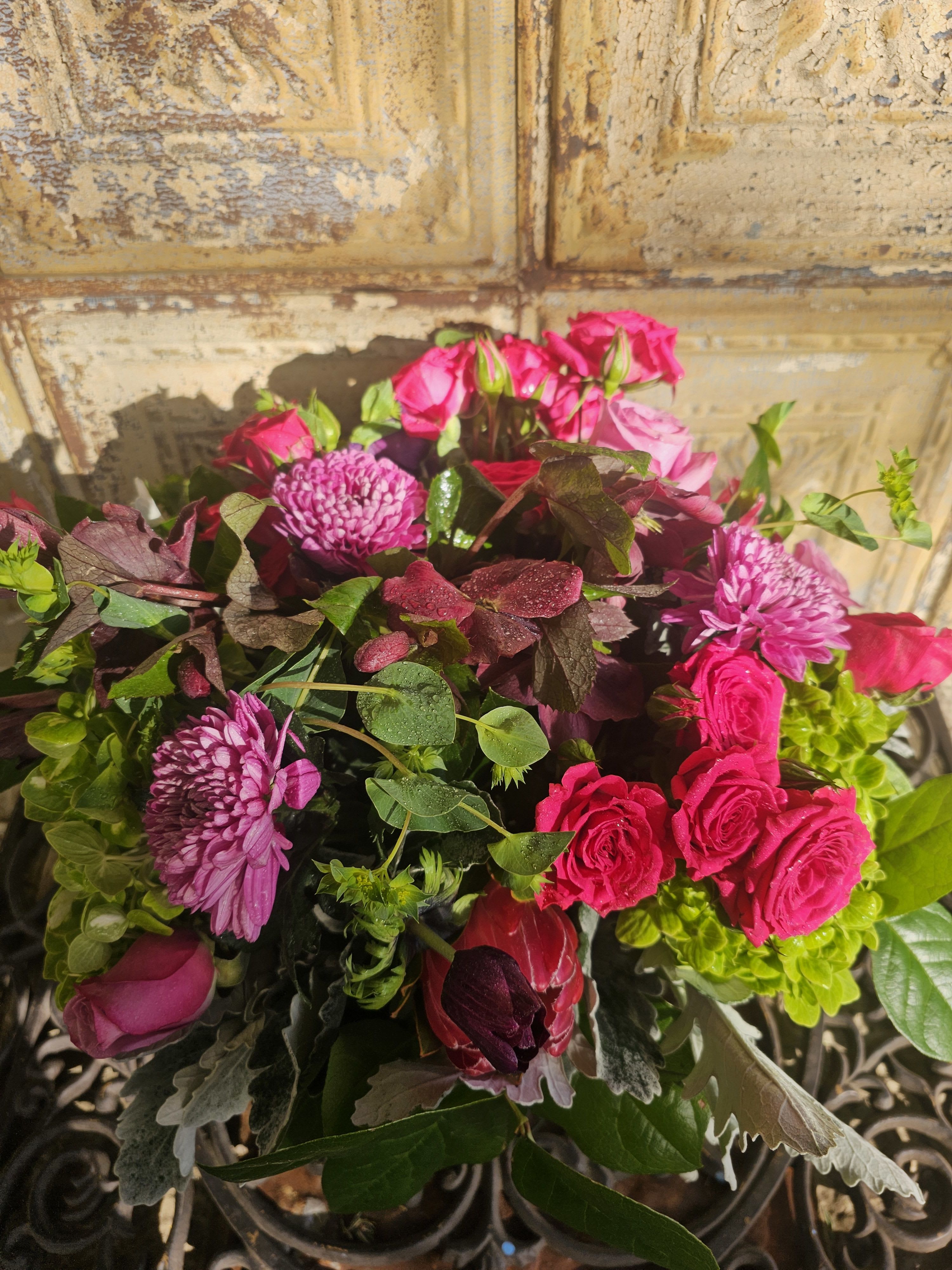 Bouquet of pink roses and purple chrysanthemums with mixed greenery