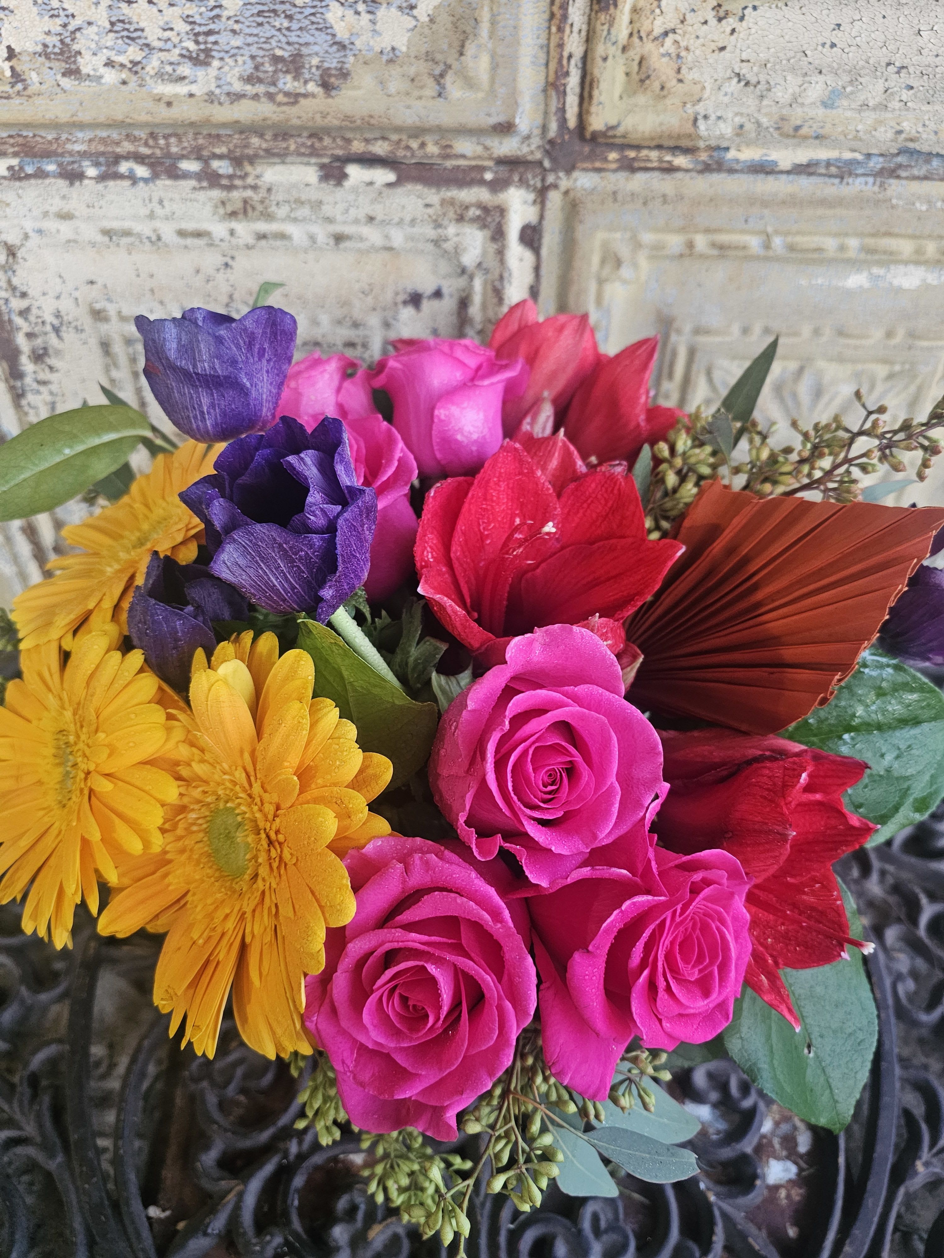 Bouquet of pink roses, purple blooms, and yellow daisies