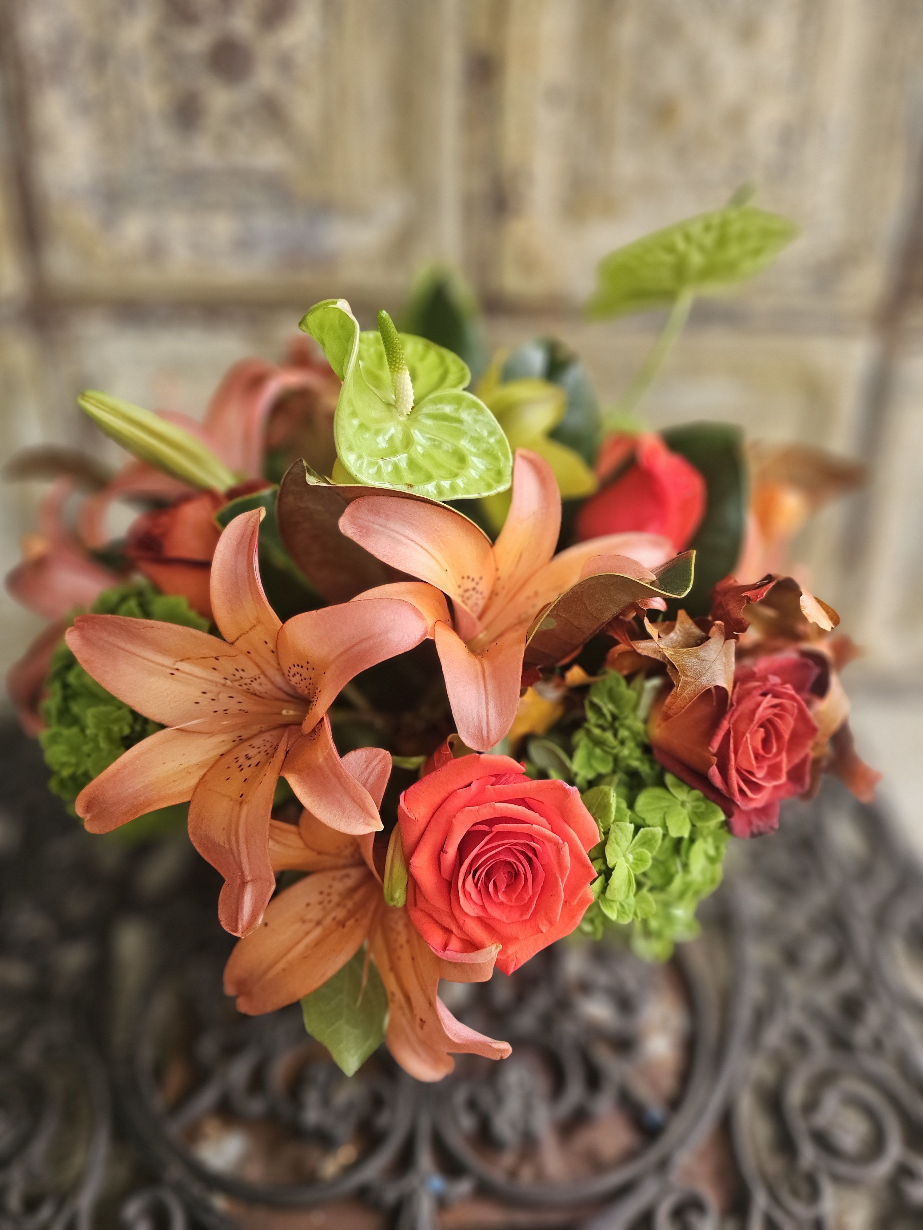 Bouquet of peach lilies, red roses, and green anthuriums