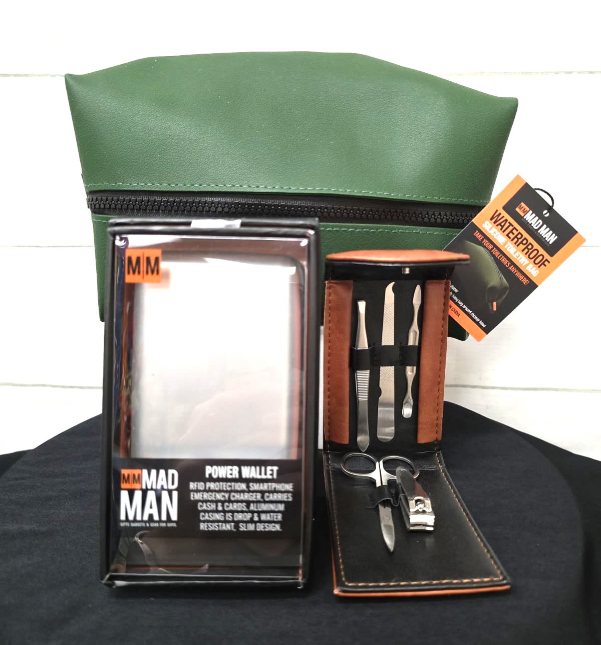 Men's grooming gift set with green toiletry bag, power wallet, and manicure kit in leather case