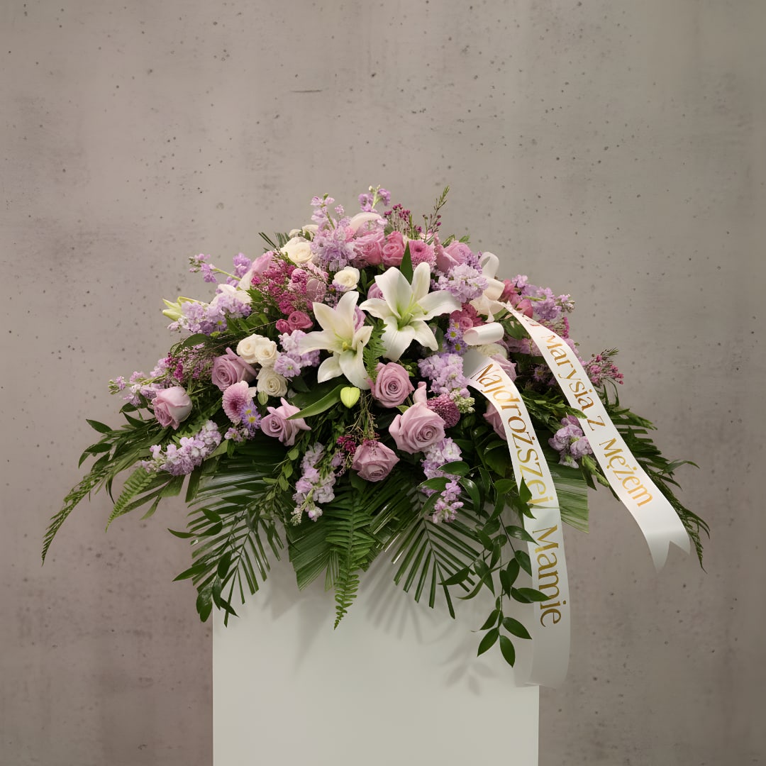 Lavender and white floral spray with ribbon on a pedestal