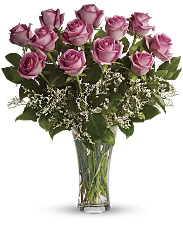 Lavender roses arranged in a clear glass vase