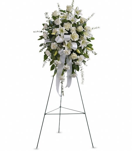 White floral standing spray on an easel with ribbon streamers