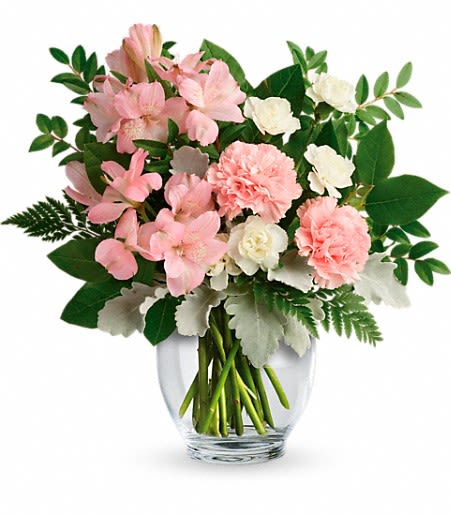 Pink and white flowers arranged in a clear glass vase