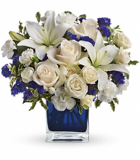 White lilies and roses in a blue glass vase
