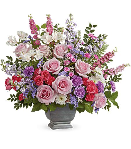 Mixed pink and purple flower arrangement in a gray urn vase