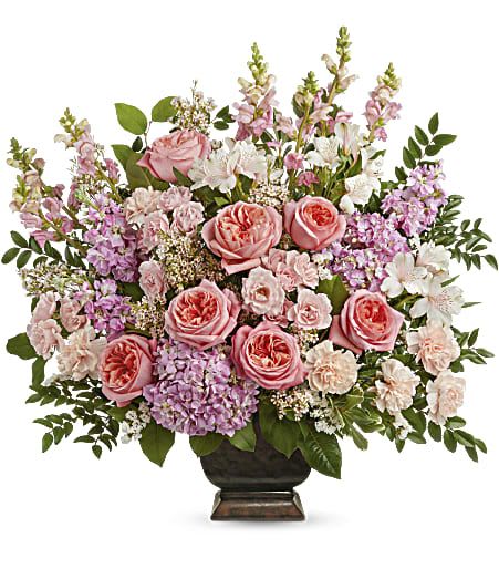 Pink roses and lavender flowers arranged in a dark vase
