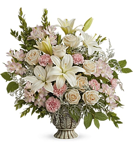 Bouquet of white lilies, cream roses, and pink carnations in a decorative vase