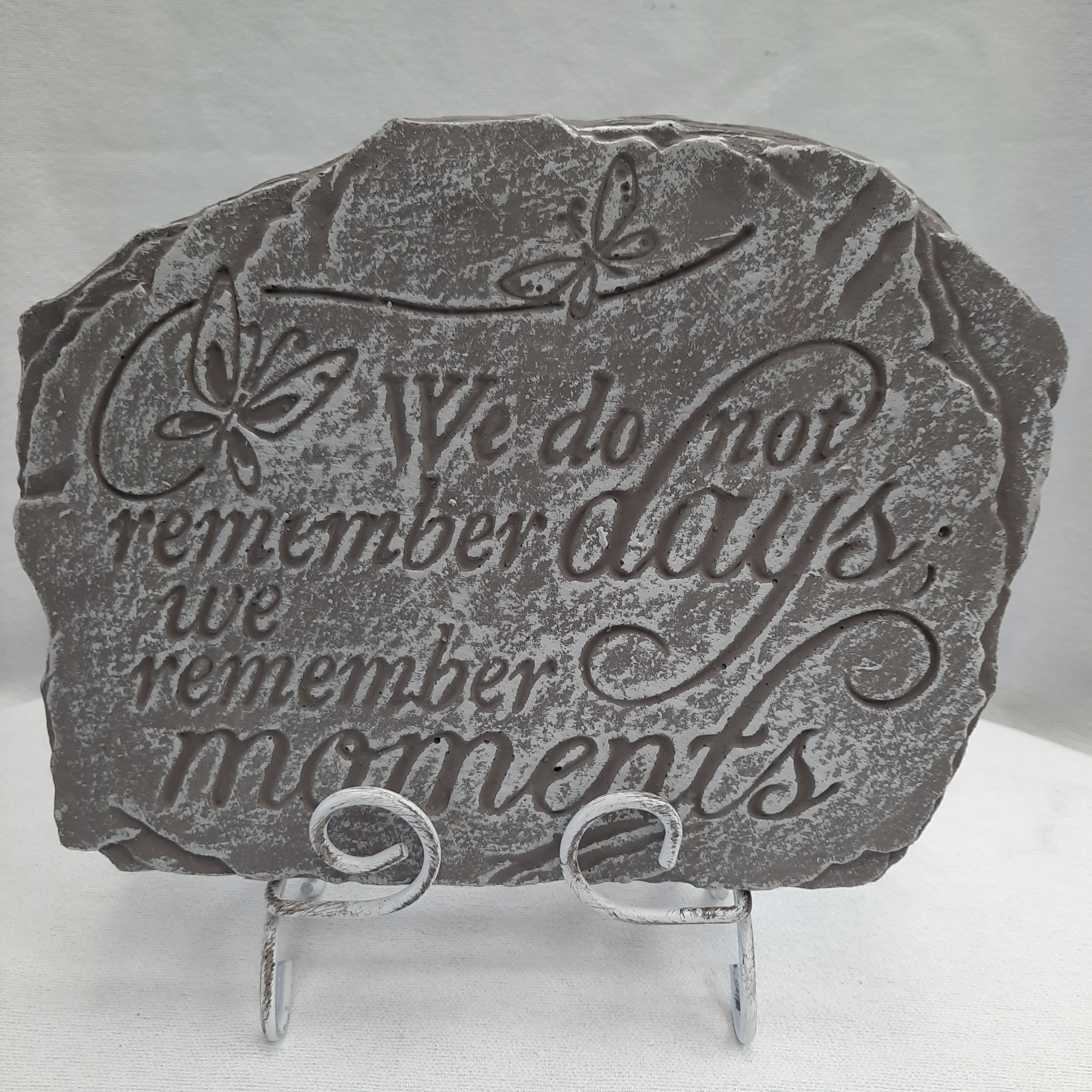 Gray memorial plaque on a metal stand with butterfly accents