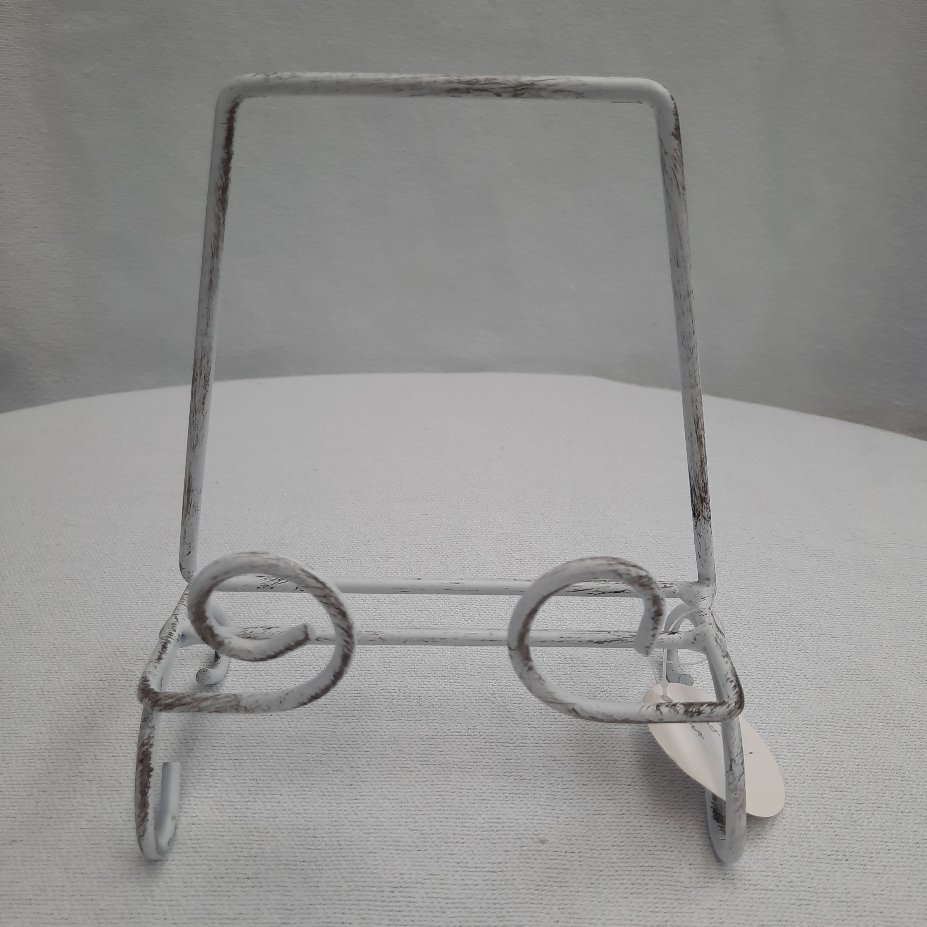 White metal display stand with curled front supports