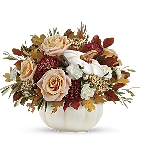 Peach roses and white flowers arranged in a white pumpkin vase
