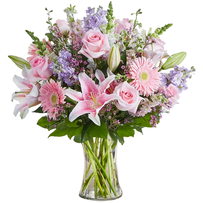 Excellence in Bloom - Excellence In Bloom is a graceful and uplifting arrangement that celebrates beauty, care, and thoughtful design. Soft pink gerbera daisies and roses create a warm, welcoming foundation, while elegant pink lilies add height and gentle drama. Accents of lavender and white stock, along with delicate waxflower, bring texture and a light, airy feel that ties everything together beautifully. Arranged in a clear glass vase, this bouquet feels polished, refined, and effortlessly elegant.  Perfect for honoring achievements, celebrating milestones, or simply sending a message of admiration and appreciation, Excellence In Bloom is a timeless way to let someone know just how special they are.