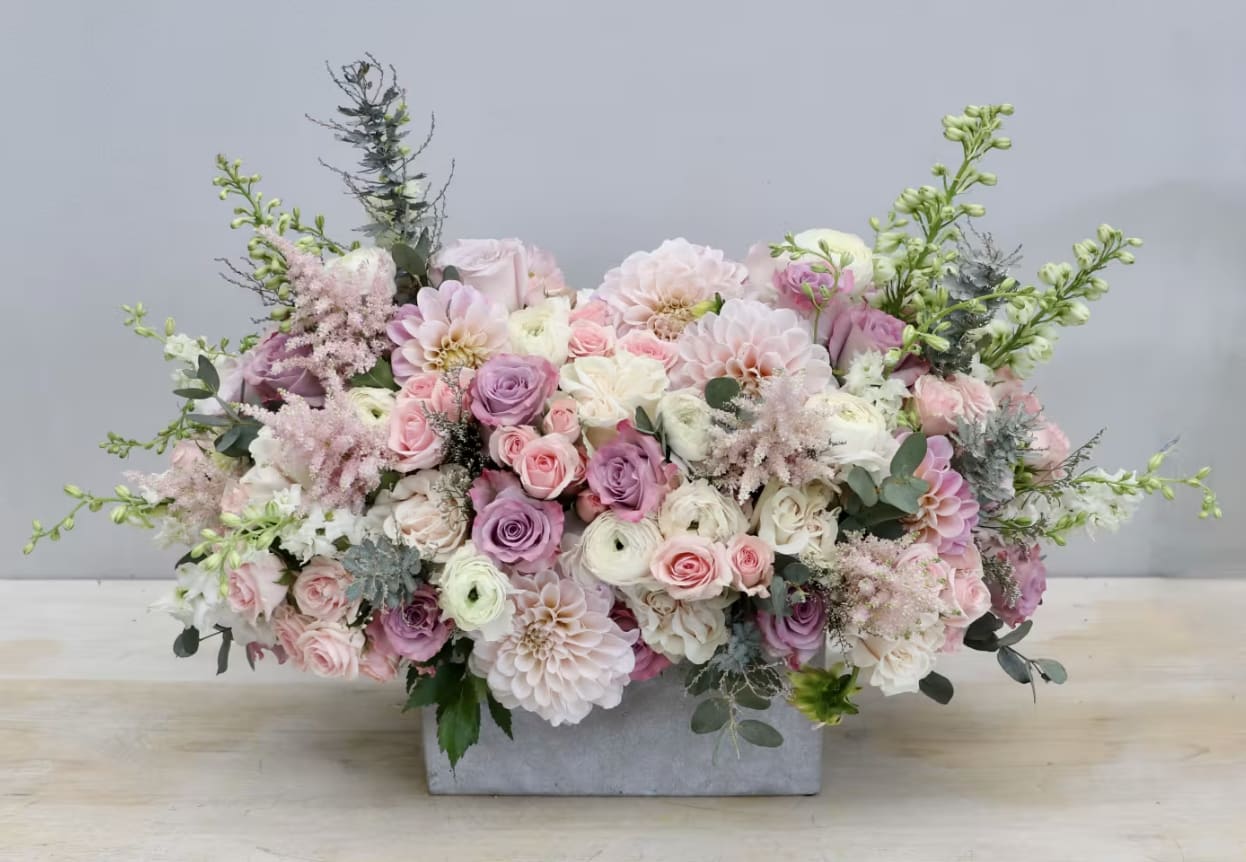 Pastel floral arrangement in a rectangular gray vase
