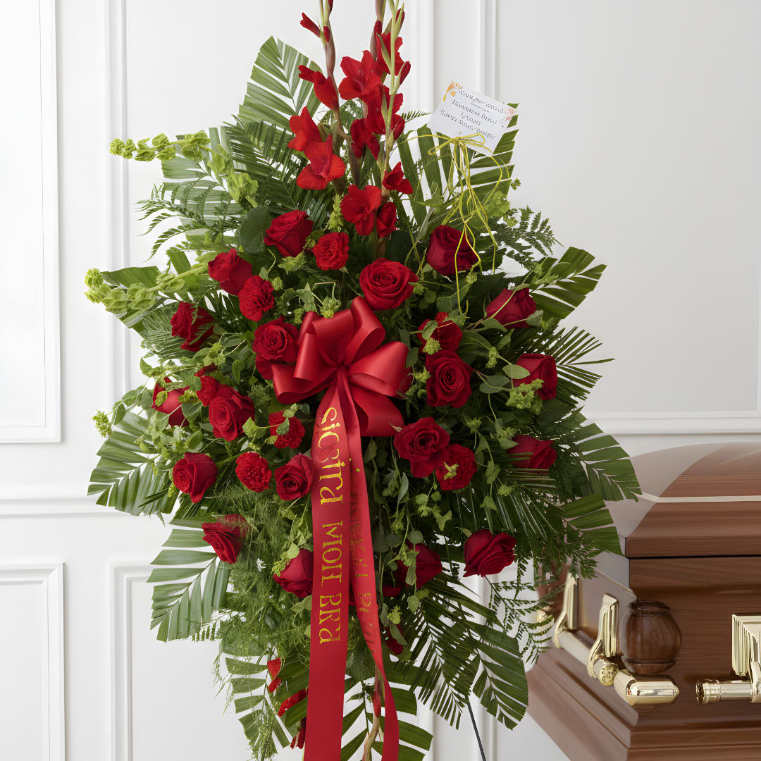 Tall red rose and gladiolus funeral spray with a red ribbon