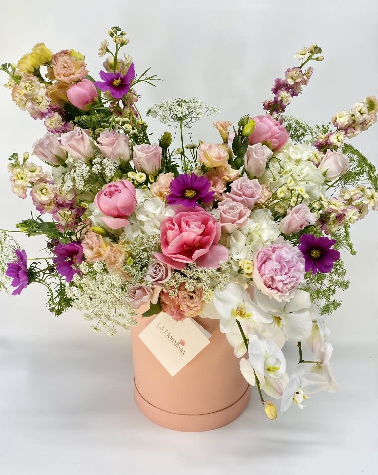 Mixed pink and white flower arrangement in a peach hat box