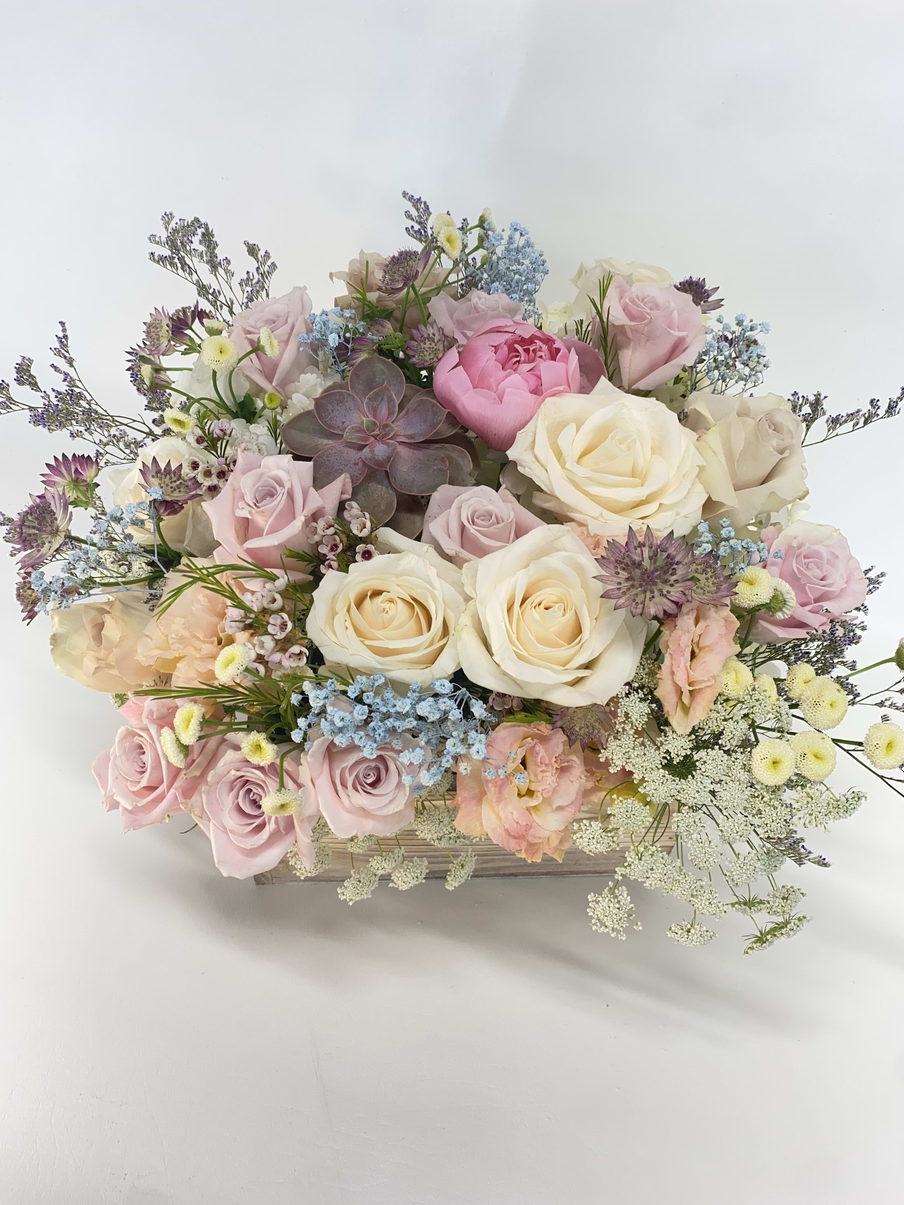 Pastel rose bouquet with a succulent in a wooden box