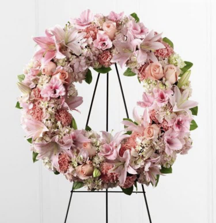 Pink floral wreath on a black stand