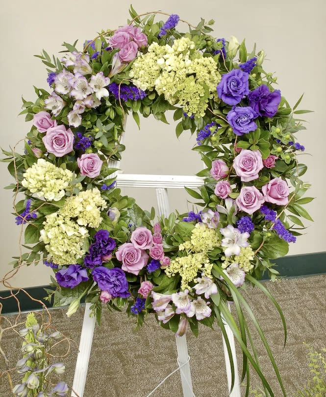 Floral wreath with pink and purple roses on a white easel
