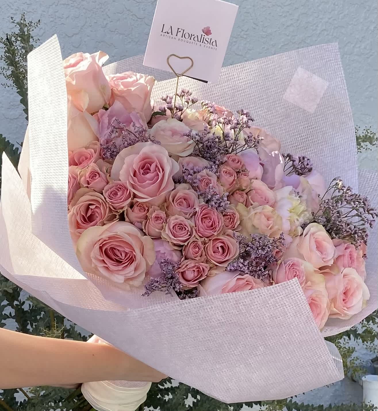 Large bouquet of pink roses wrapped in pale pink paper
