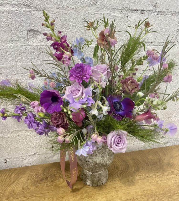 Lavender and purple mixed bouquet in a textured vase