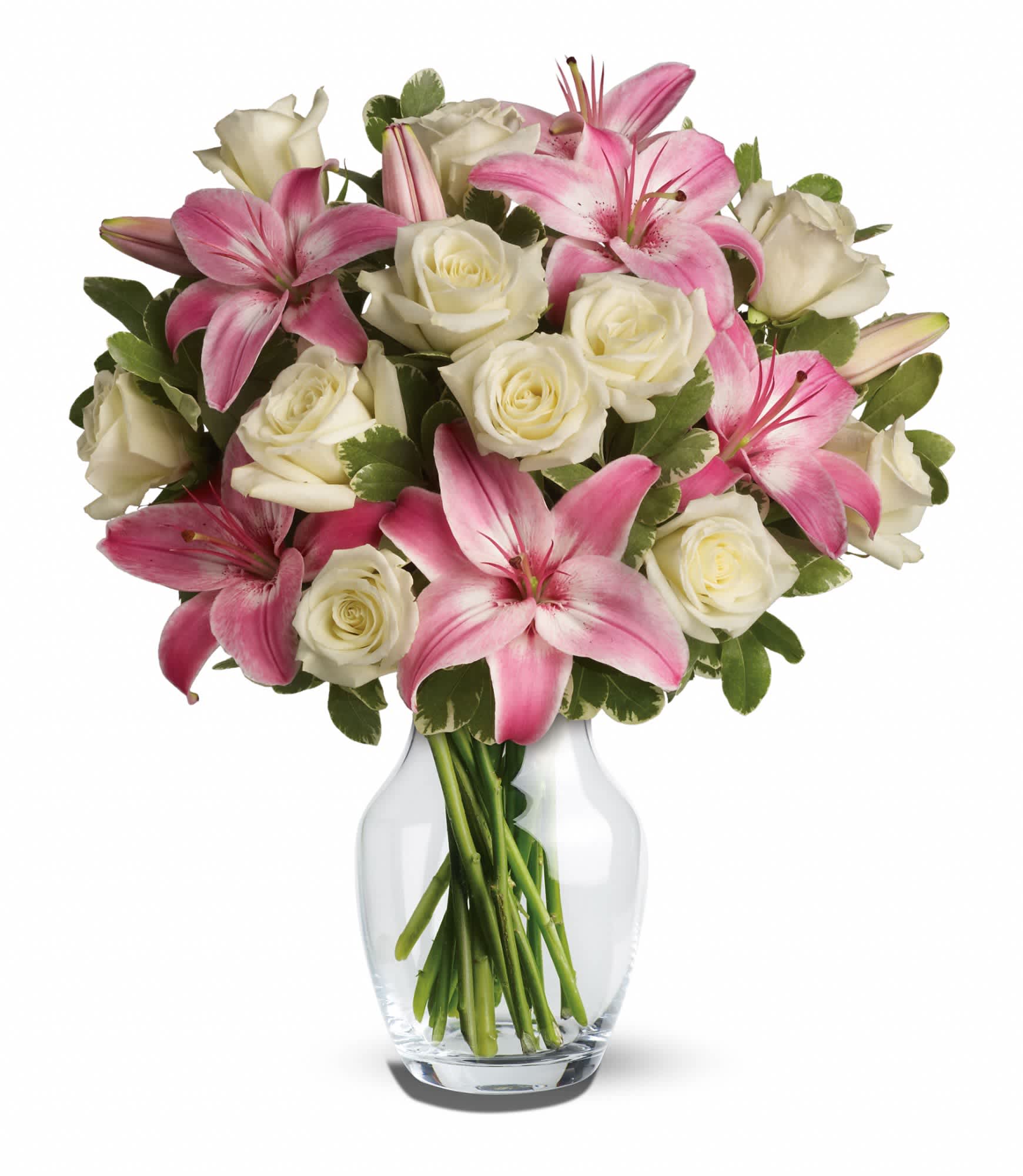 Arrangement of pink lilies and white roses in a clear glass vase