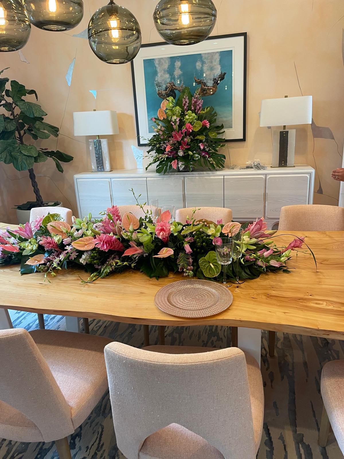 Long pink and white floral table runner with matching tall arrangement on a dining sideboard