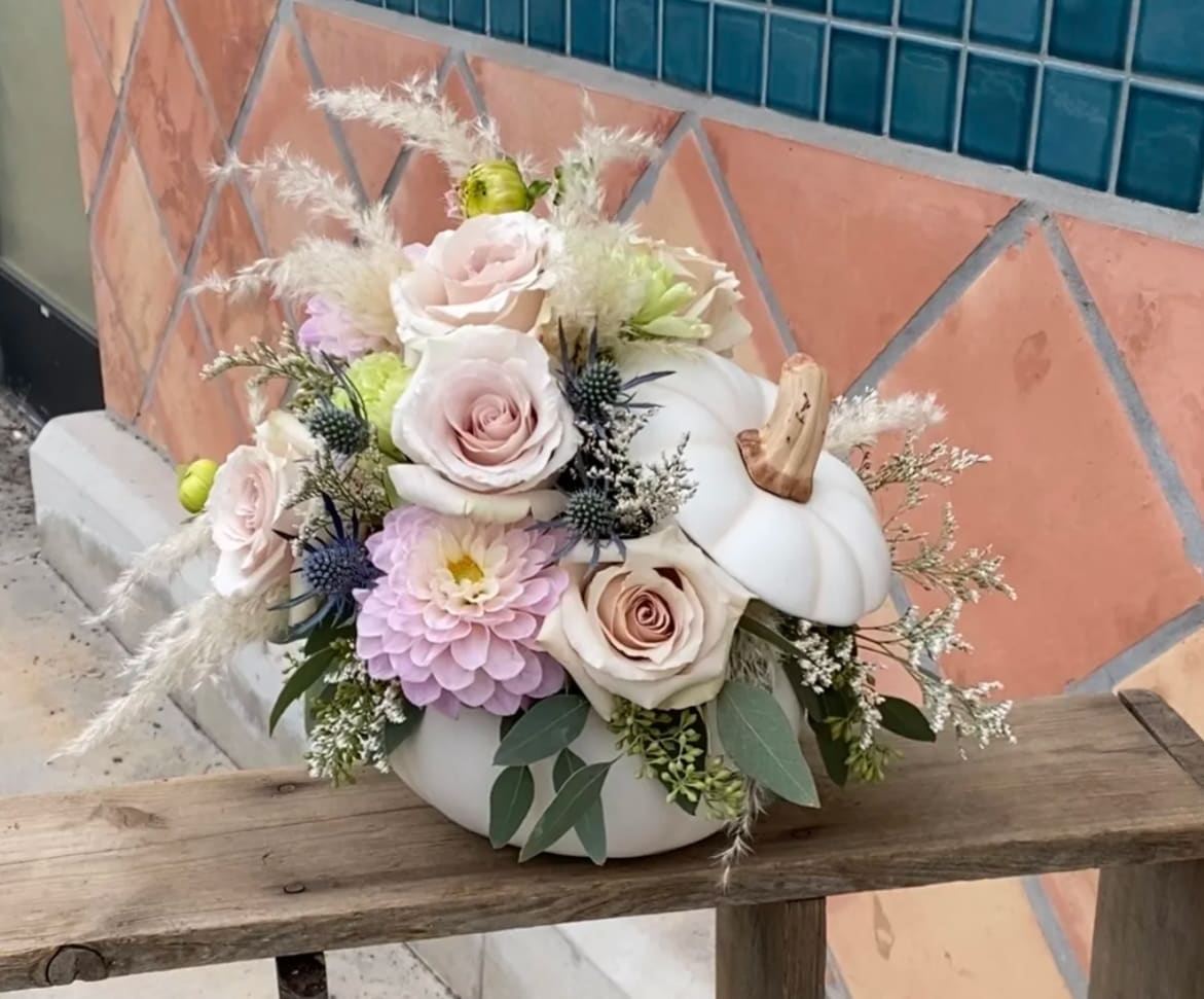 Pastel floral arrangement in a white pumpkin container