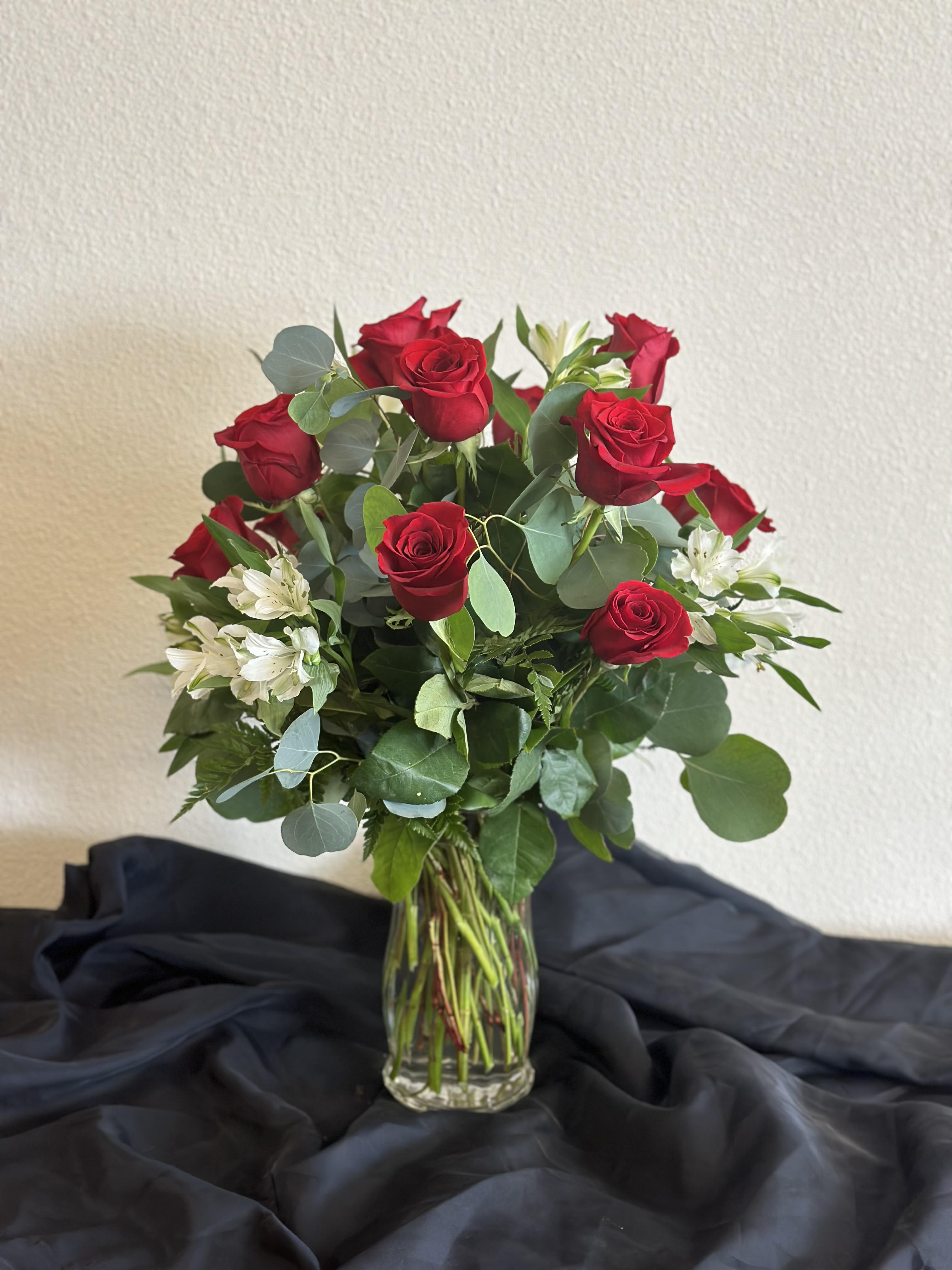 Red roses and white alstroemeria in a clear glass vase