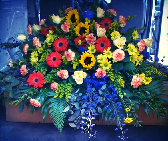 Large floral spray with sunflowers, gerbera daisies, and roses