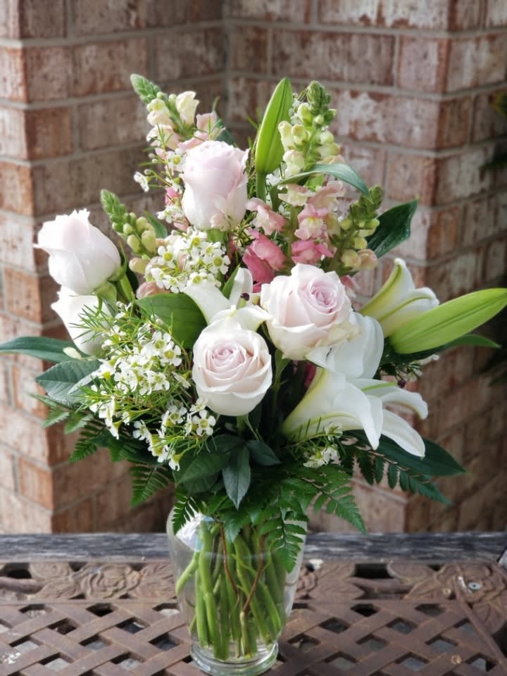 Blossoming Romance - Love is in the air. Or if it isn't, it will be when you surprise her with a gorgeous array of light pink spray roses, fragrant white lilies and other favorites in a sparkling glass vase. You know when she'll love it the most? When it's a total surprise. *Deluxe is featured in the picture* 