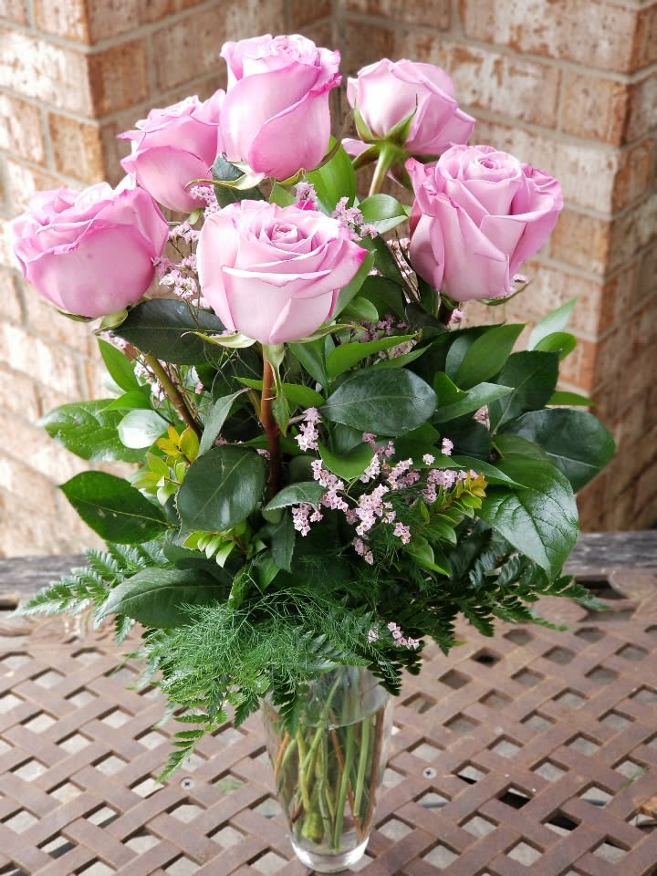 Pink roses arranged in a clear glass vase
