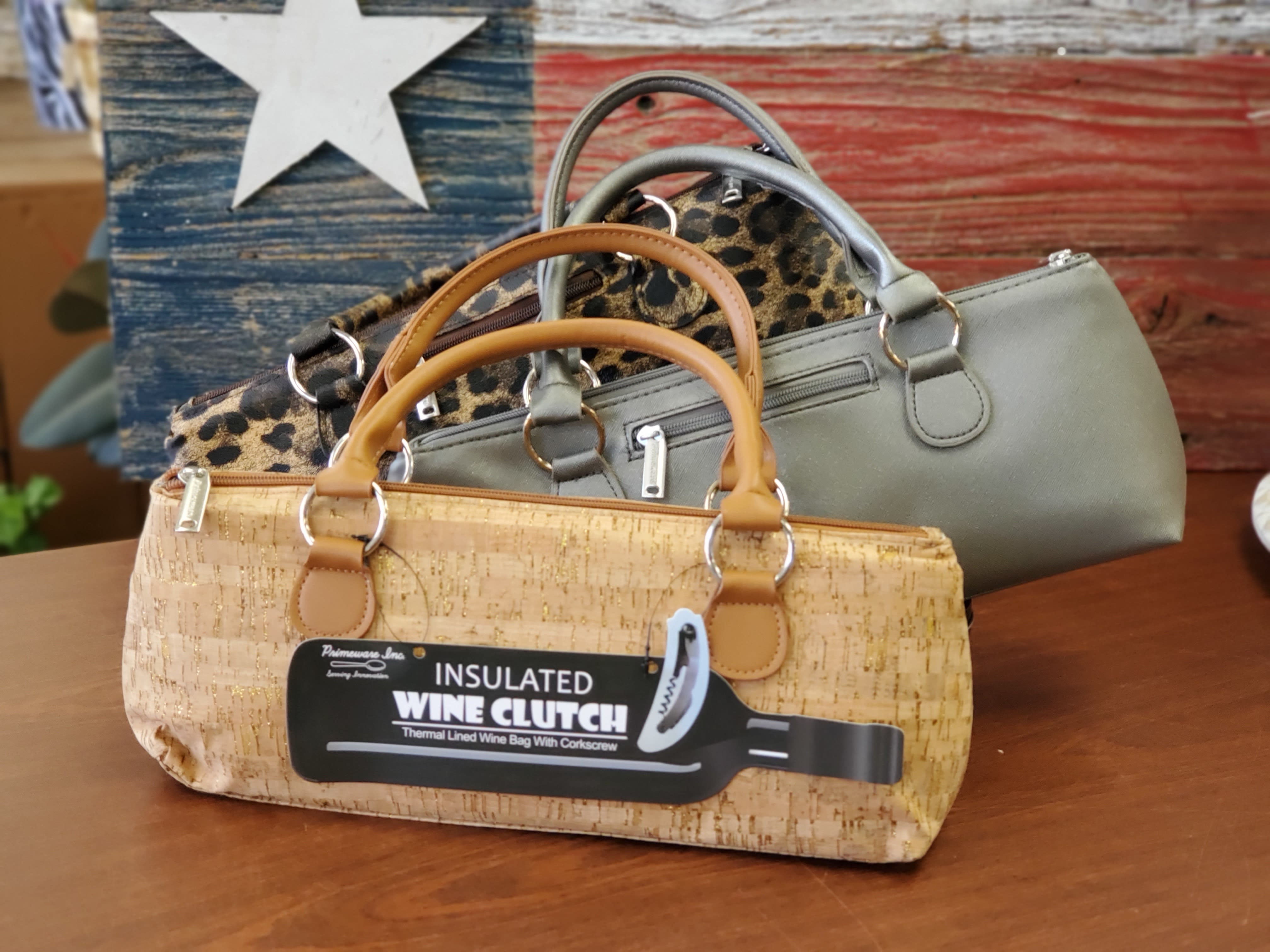 Three insulated wine clutch bags in cork, leopard print, and gray