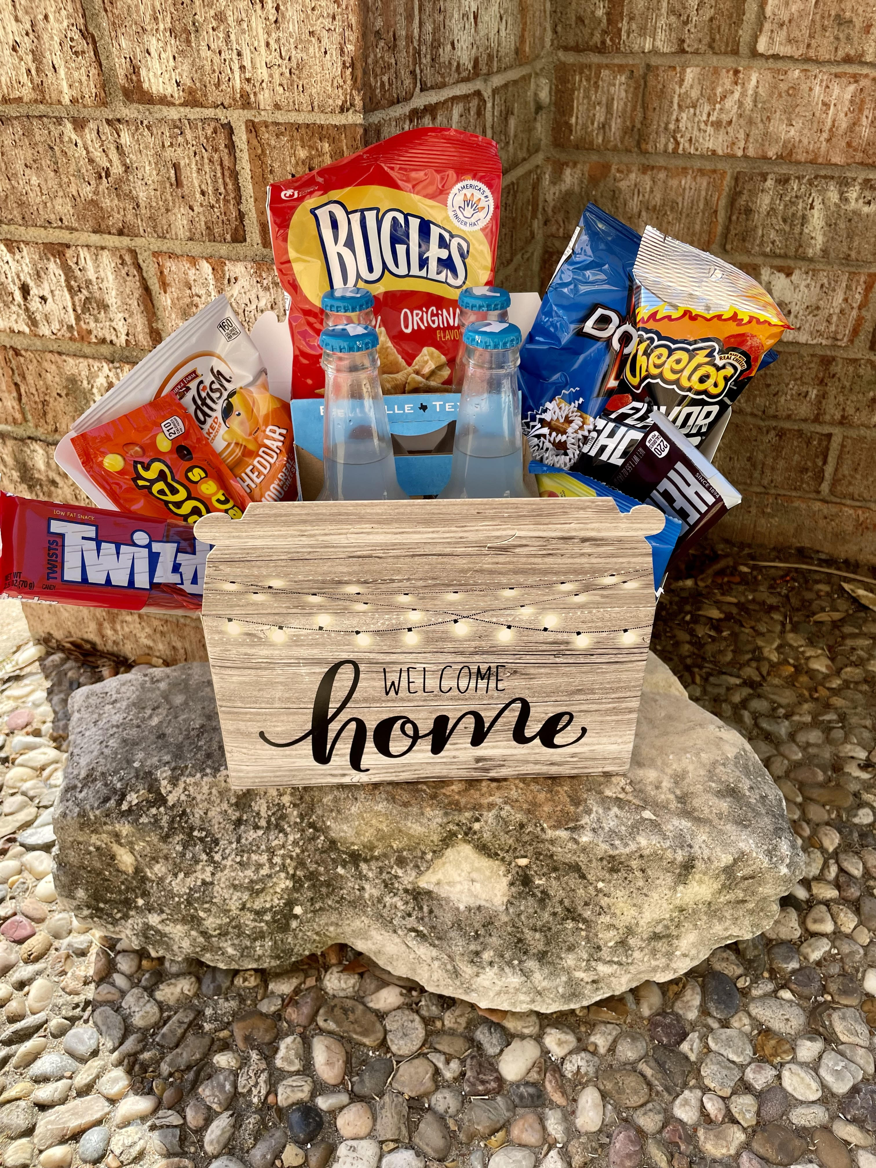 Snack basket with chips, candy, and bottled drinks in a welcome home box