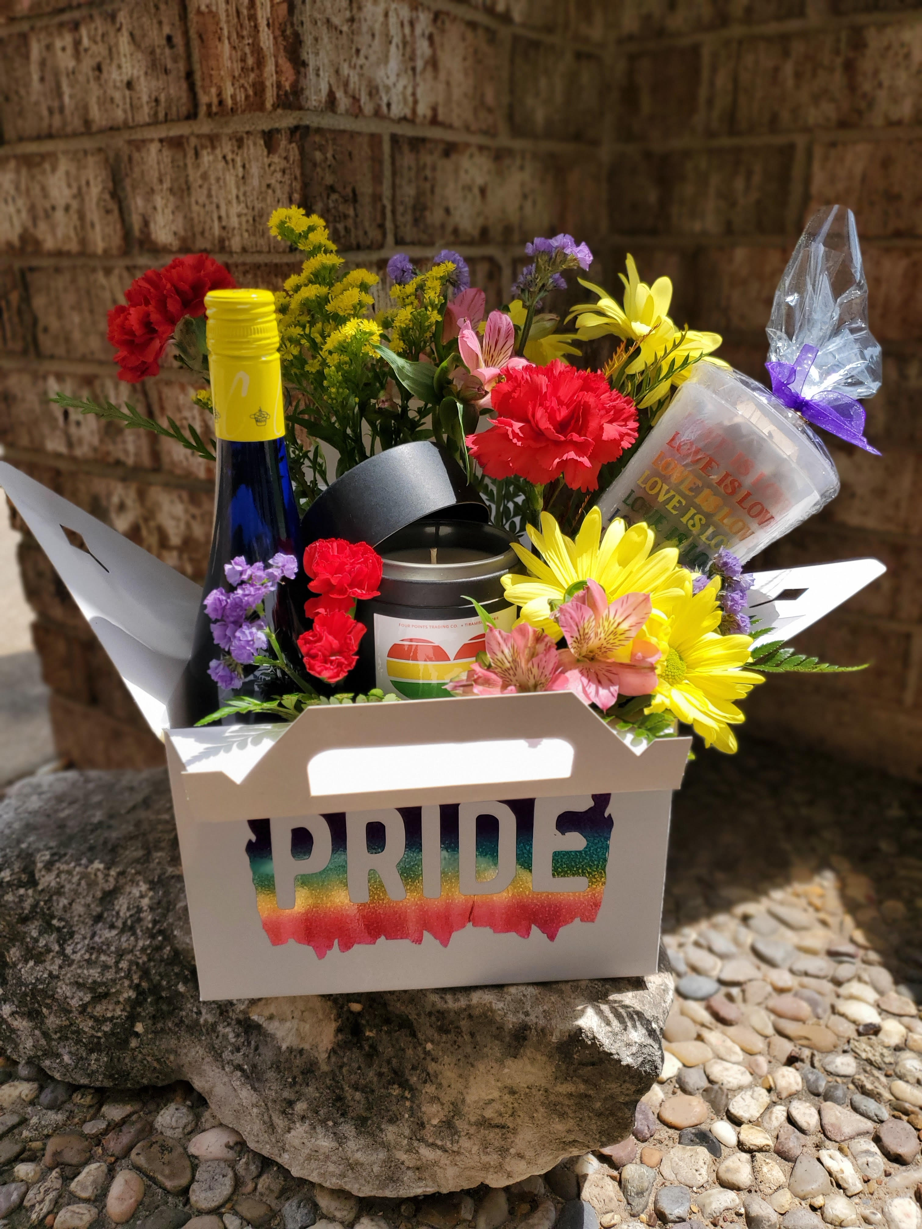 Rainbow flower gift box with a Pride label, bottle, candle, and cup