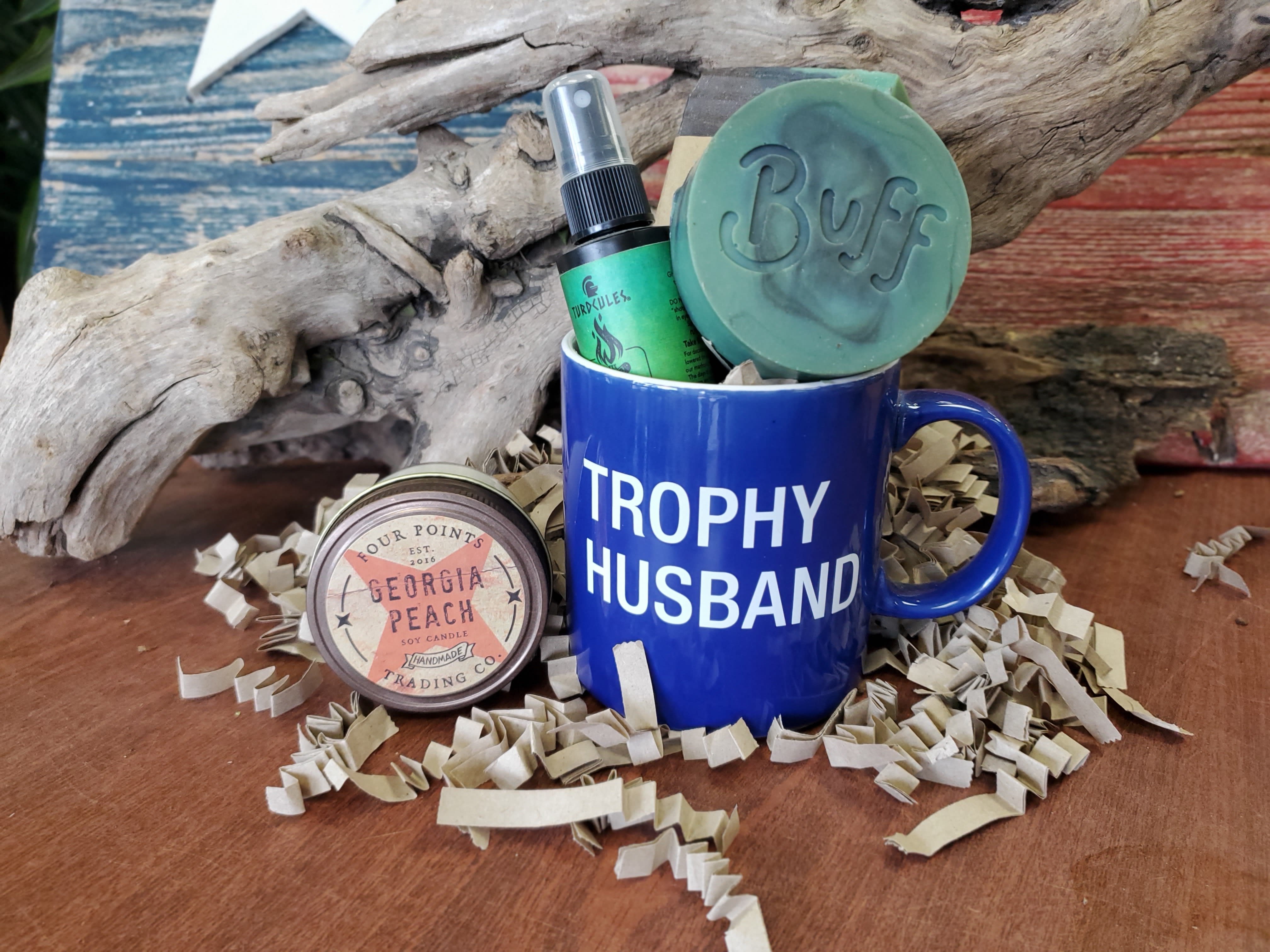 Gift mug with candle and soap on shredded paper filler