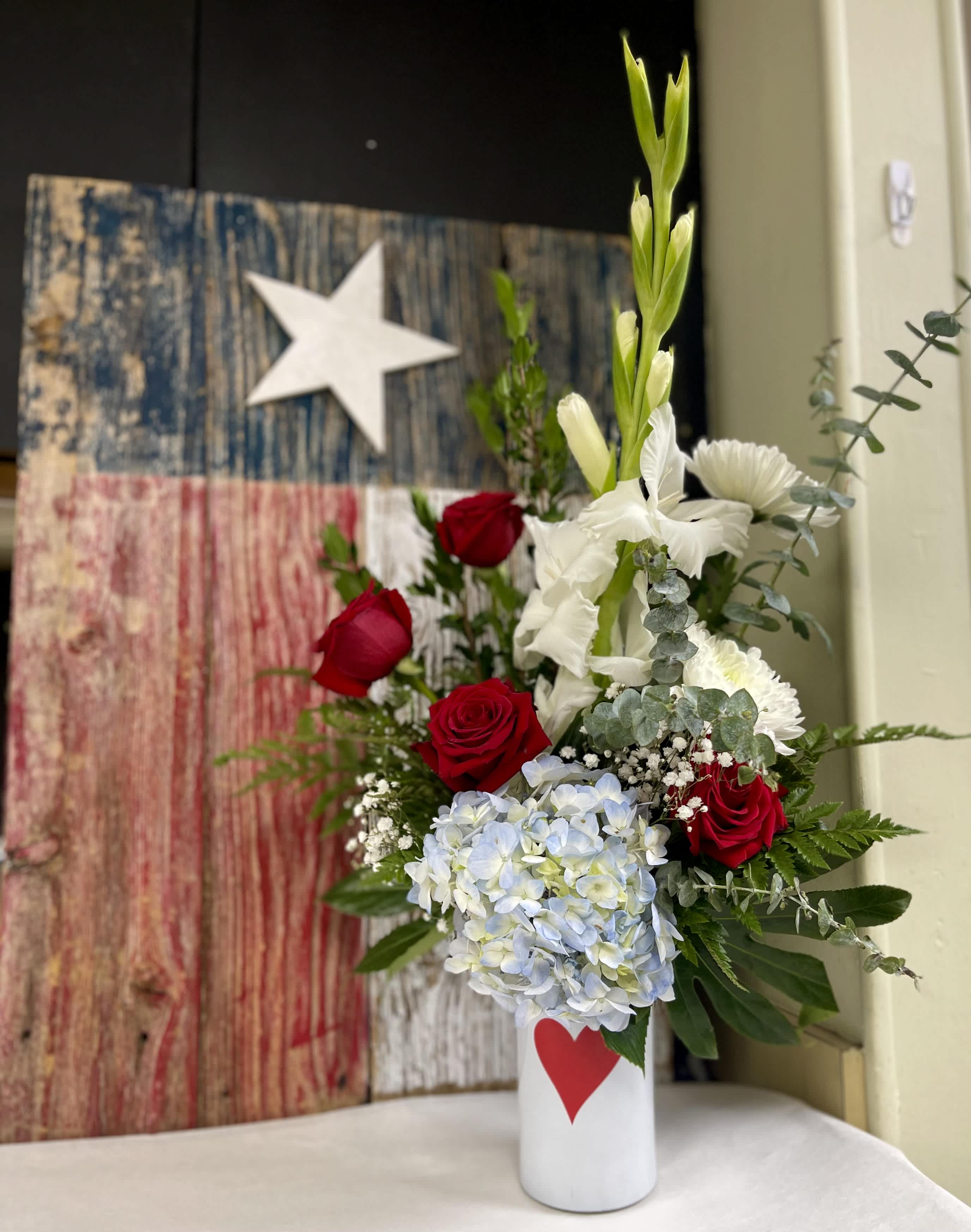 Red roses and white flowers in a white vase with a red heart
