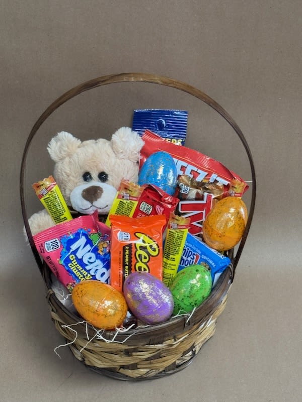 Basket of candy with a teddy bear and colorful Easter eggs